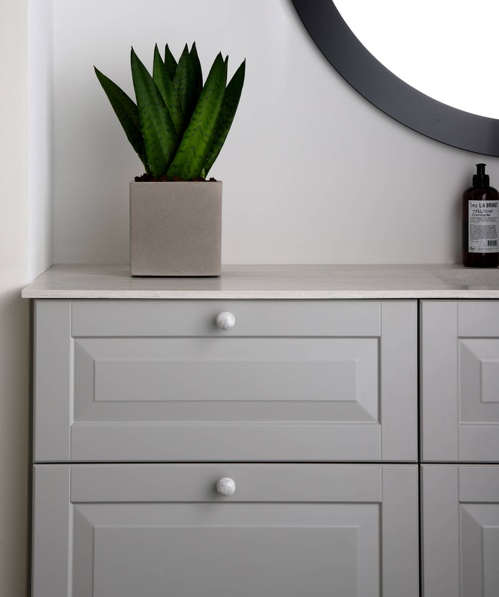 Romantisk badeværelse Nordic i lys grå farve Sky fra INVITA med klassiske detaljer som fyldniner og glaslåger med sprosser, marmor håndtag og sort armatur