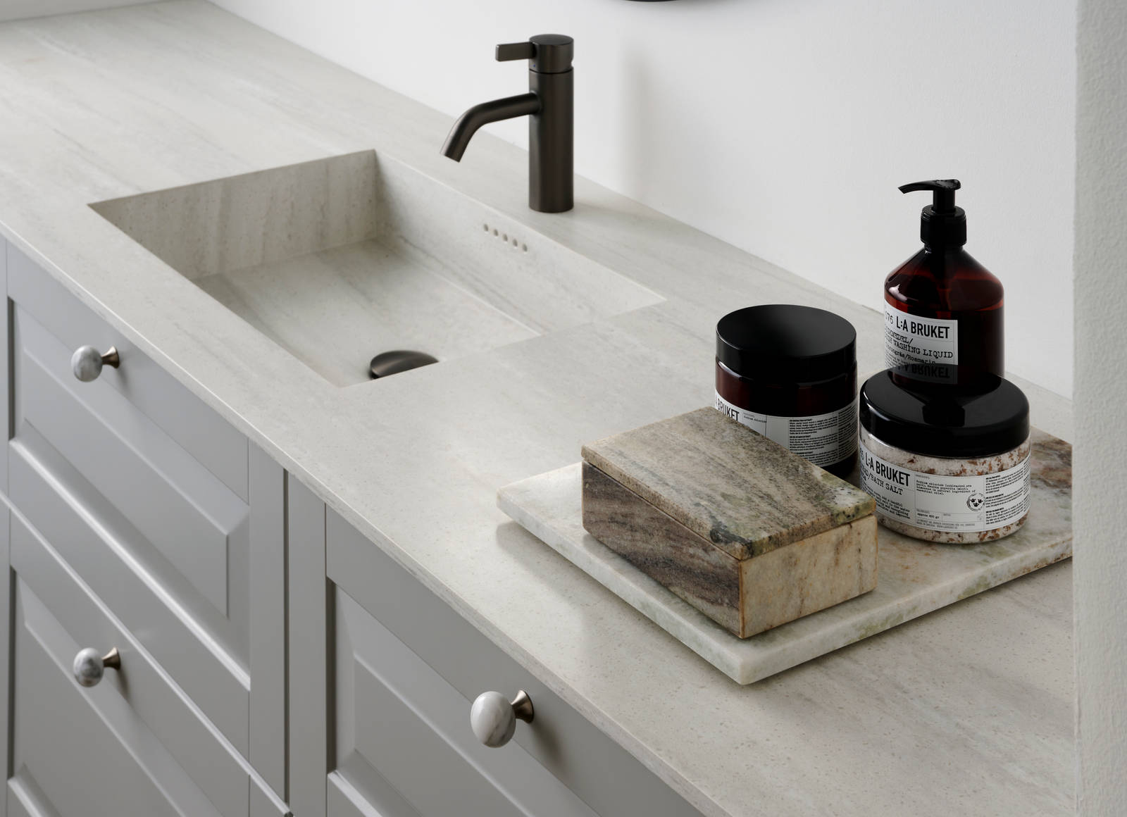 Nærbillede af sort armatur i romantisk badeværelse Nordic i lys grå farve Sky fra INVITA med klassiske detaljer som fyldniner og glaslåger med sprosser, marmor håndtag