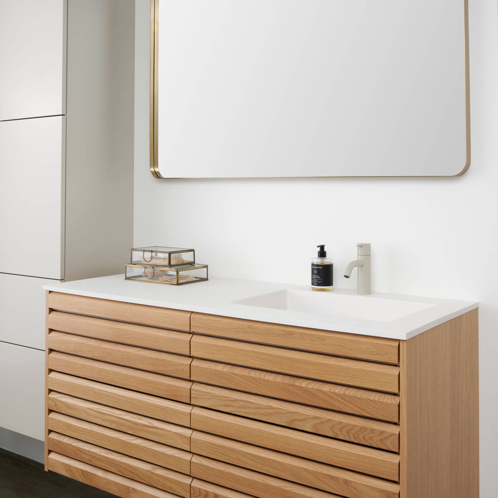 Snedkerbadeværelse Ikon Finér eg natur fra INVITA med håndplukkede, massive egetræslameller med hvid vask og lys grå armatur