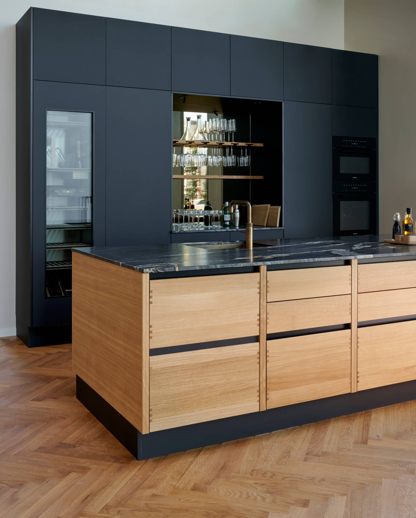 Køkkenøya Glød fra INVITA , skuffer i massivt egetræ med fingertappede samlinger og sort granit bordplade