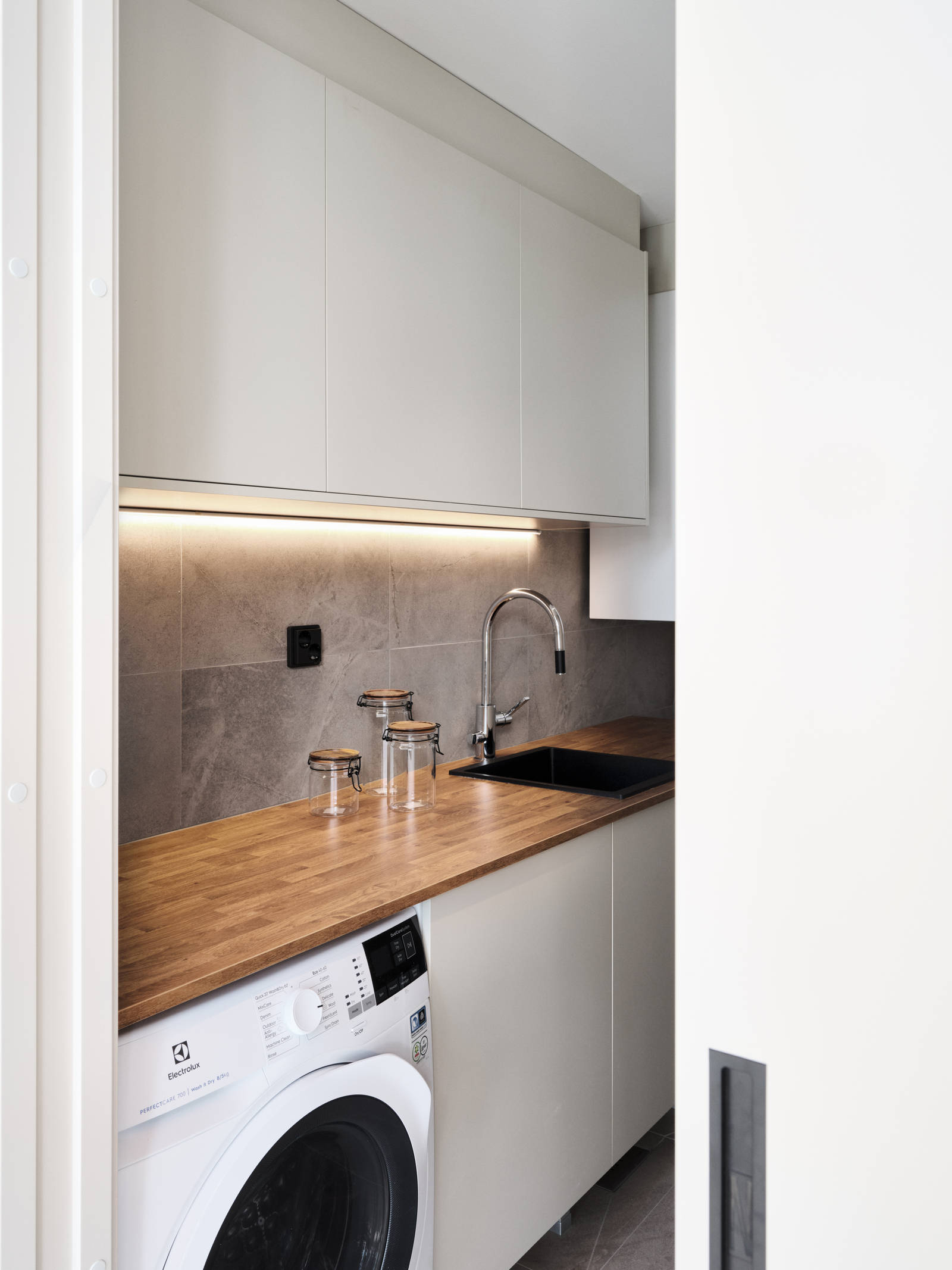 kodinhoitohuoneen ovimalleina toimii melamiini värissä Hiekka ja tasoksi valikoitui helppohoitoinen ja kestävä laminaatti sävyssä antiikkitammi.