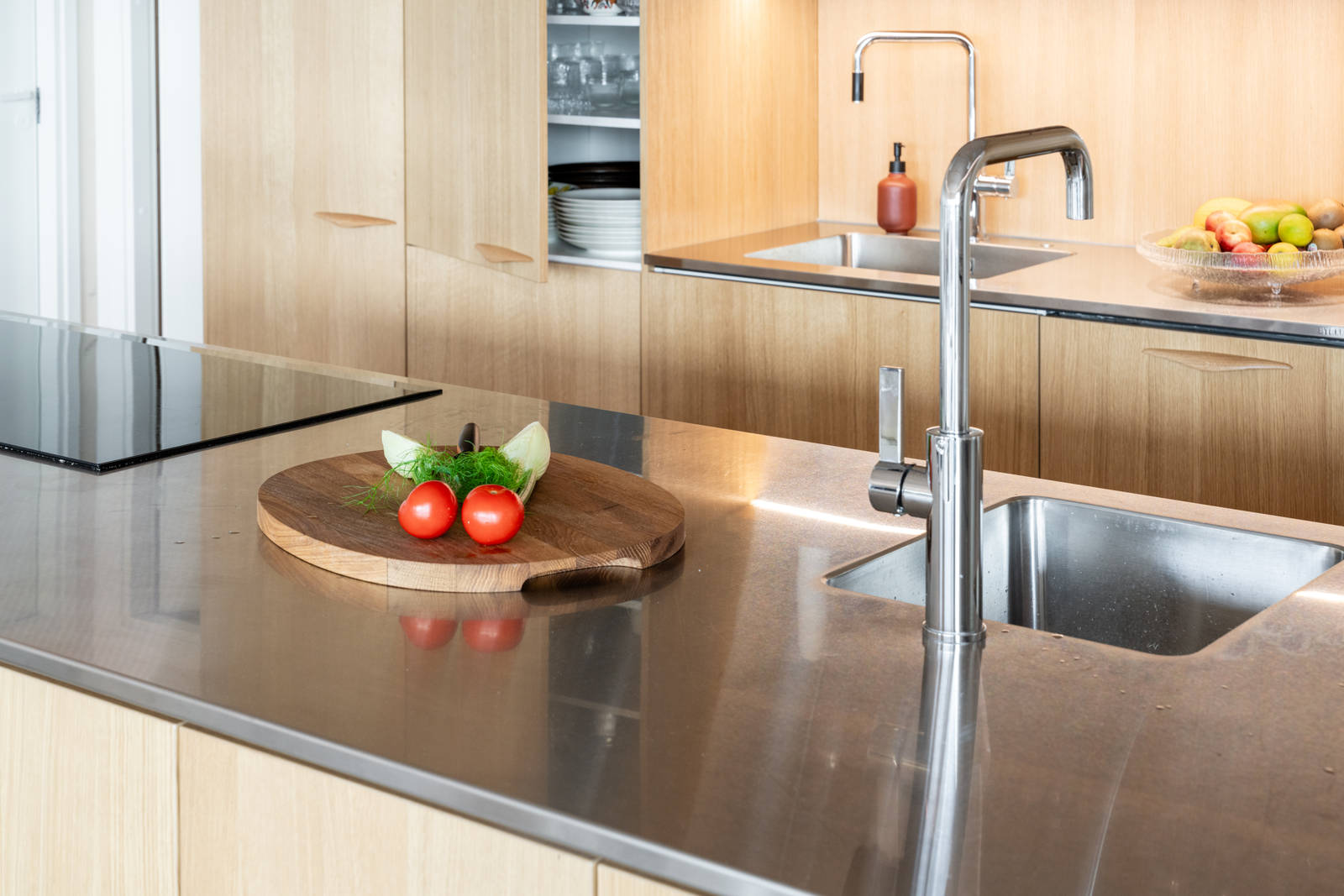 Aitoa luonnontammea Novartilta, yhdistelmä yhteensopivia puisia ja painonappikahvoja, keittiösaareke hanalla, tiskiallas ja ruostumattomasta teräksestä valmistettu työtaso.