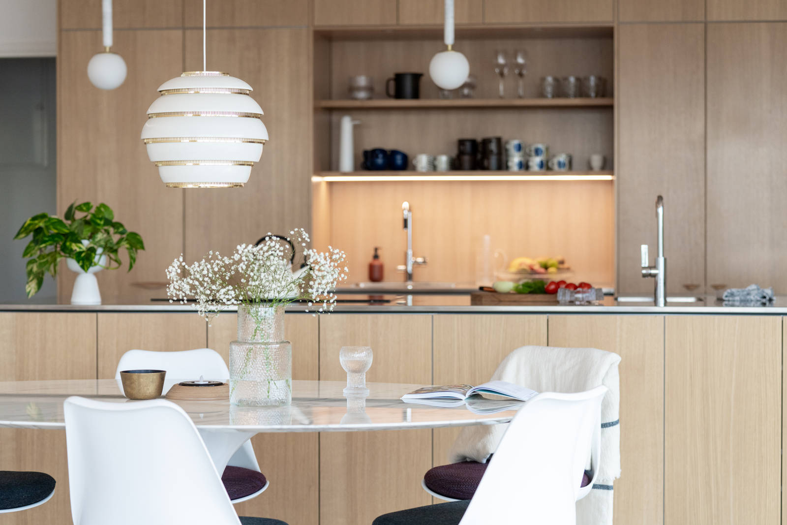 Aitoa luonnontammea Novartilta, yhdistelmä yhteensopivia puisia ja painonappikahvoja, keittiösaareke hanalla, tiskiallas ja ruostumattomasta teräksestä valmistettu työtaso.