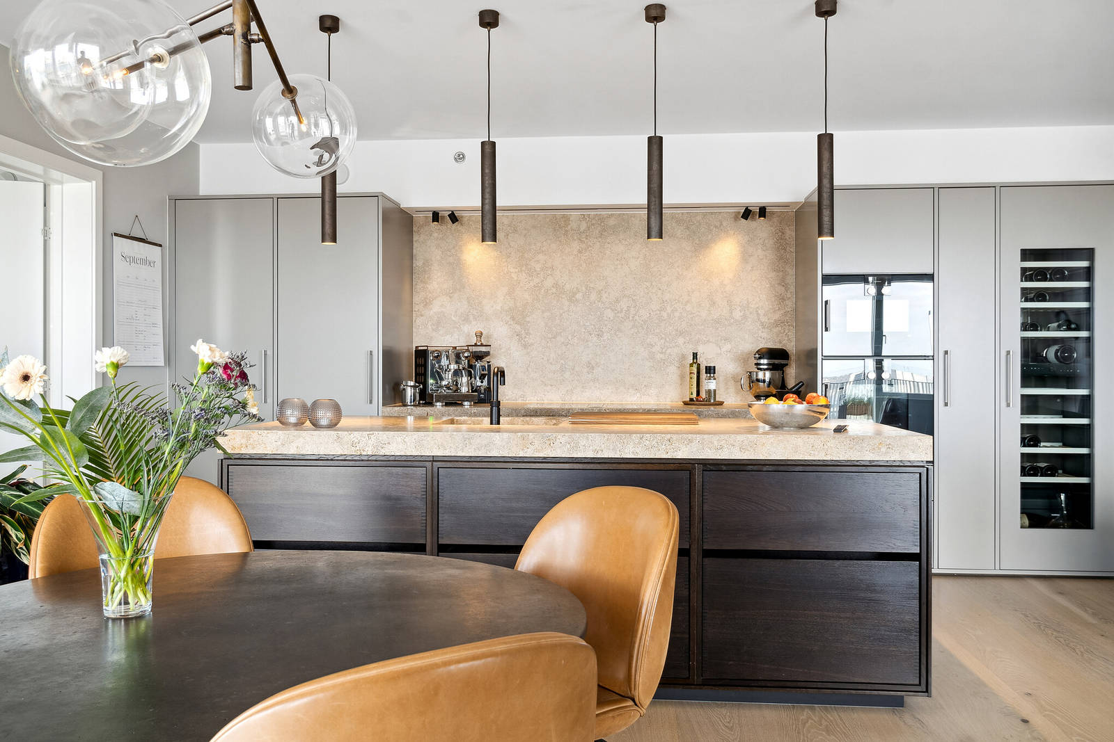 Grå Avantgarde högskåp skapar en minimalistisk bakgrund till köksön i rökt ek från uno form.