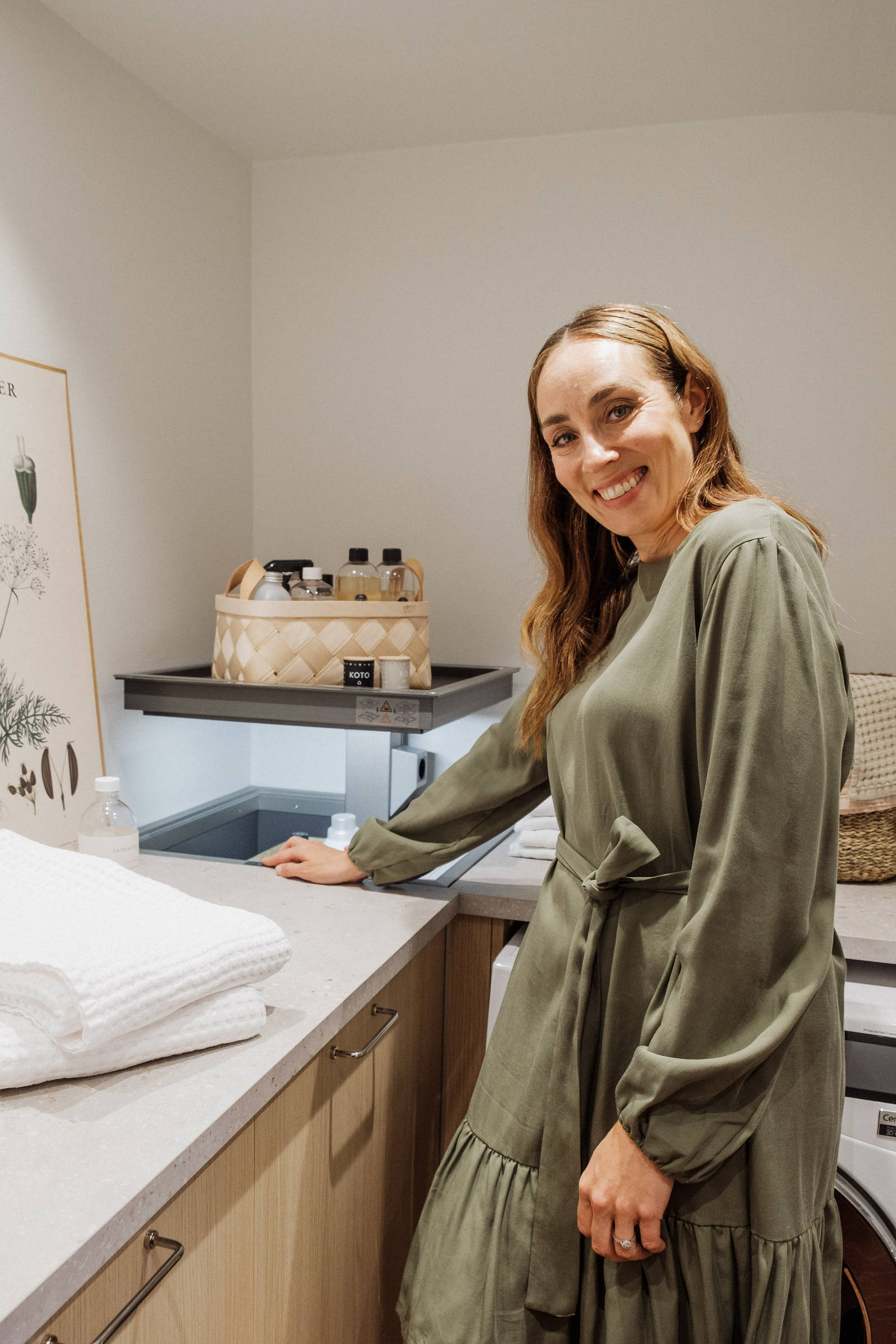 Anni Ihamäki toiminnallisessa melamiini- ja laminaattikeittiössä Hiekassa sekä lämminsävyinen vaalea tammimelamiini Novartilta, yhdistettynä kromilankakahvat ja helppohoitoinen Coral Clay mokkanahkakvartsitaso.