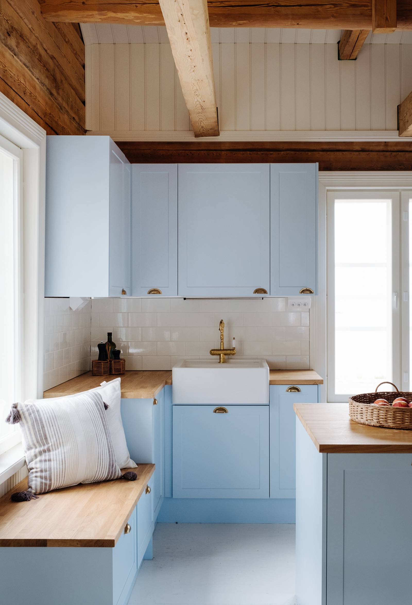 Keittiö, jossa karmiovet erikoissävyssä NCS S 1020-R90B 1800-luvun hirsitalossa, tammitasot, posliinitiskiallas ja messinkihana.