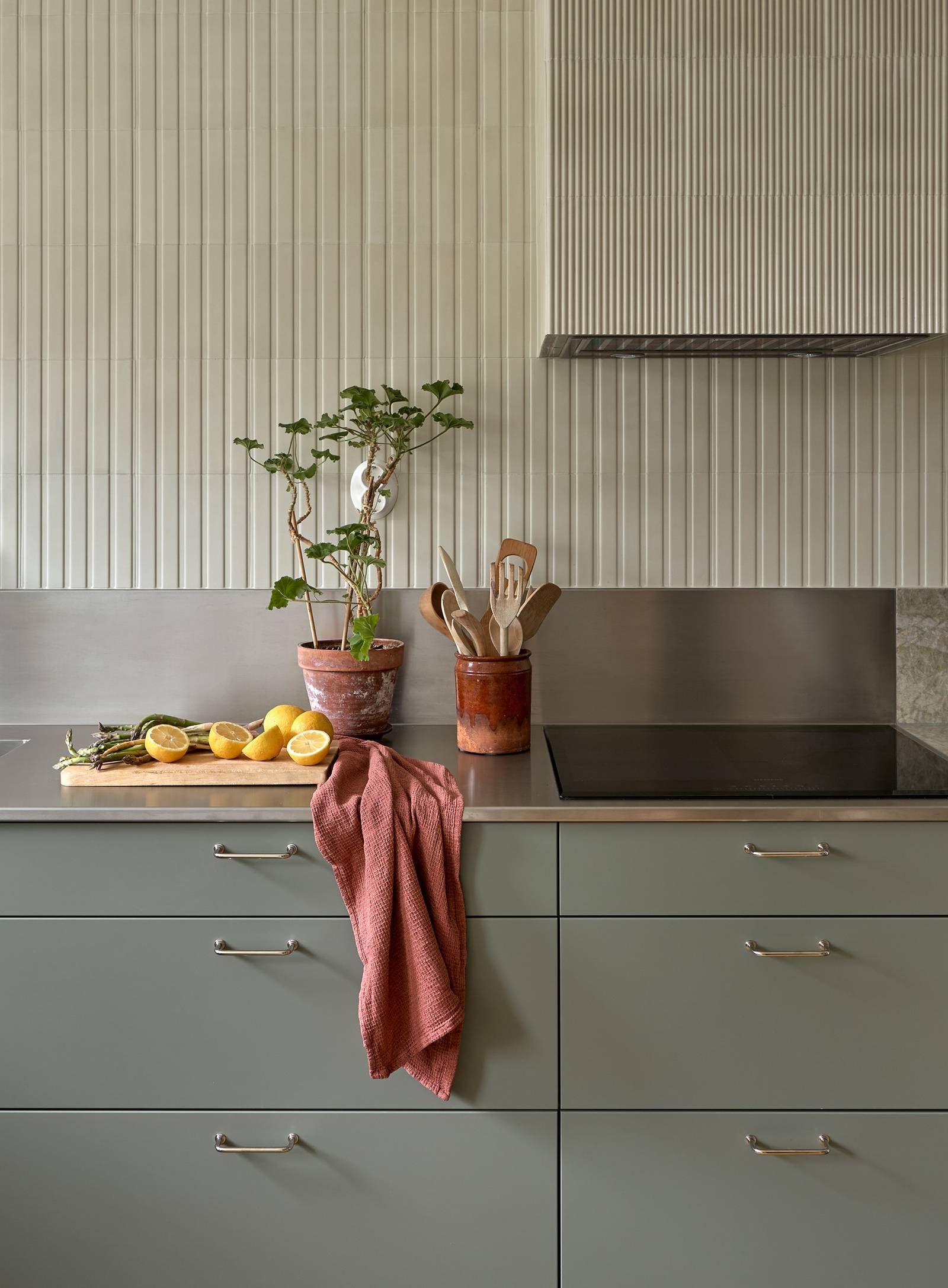 Lys grågrøn Athena Salvie køkken fra INVITA, håndtag och bordplade med splashback i rustfritt stål