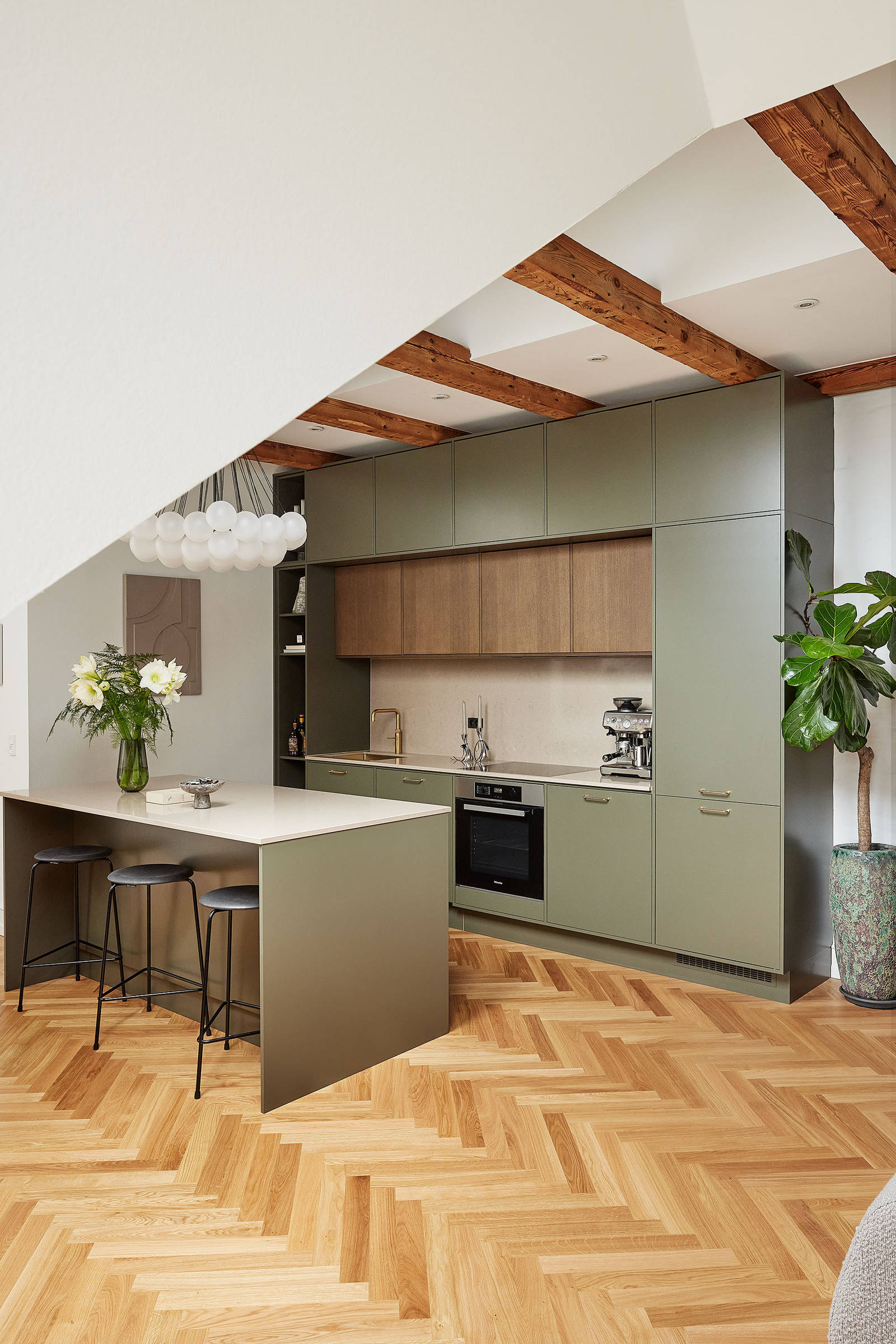 Grønt køkken med træskabe og køkkenø