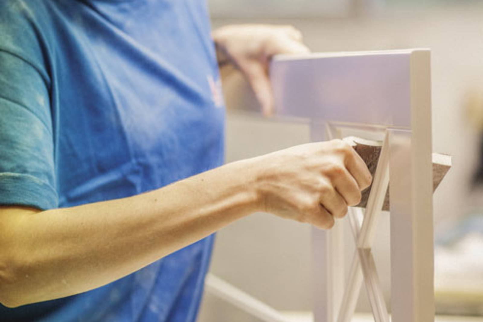 Närbild av någon som slipar en vitrinlucka