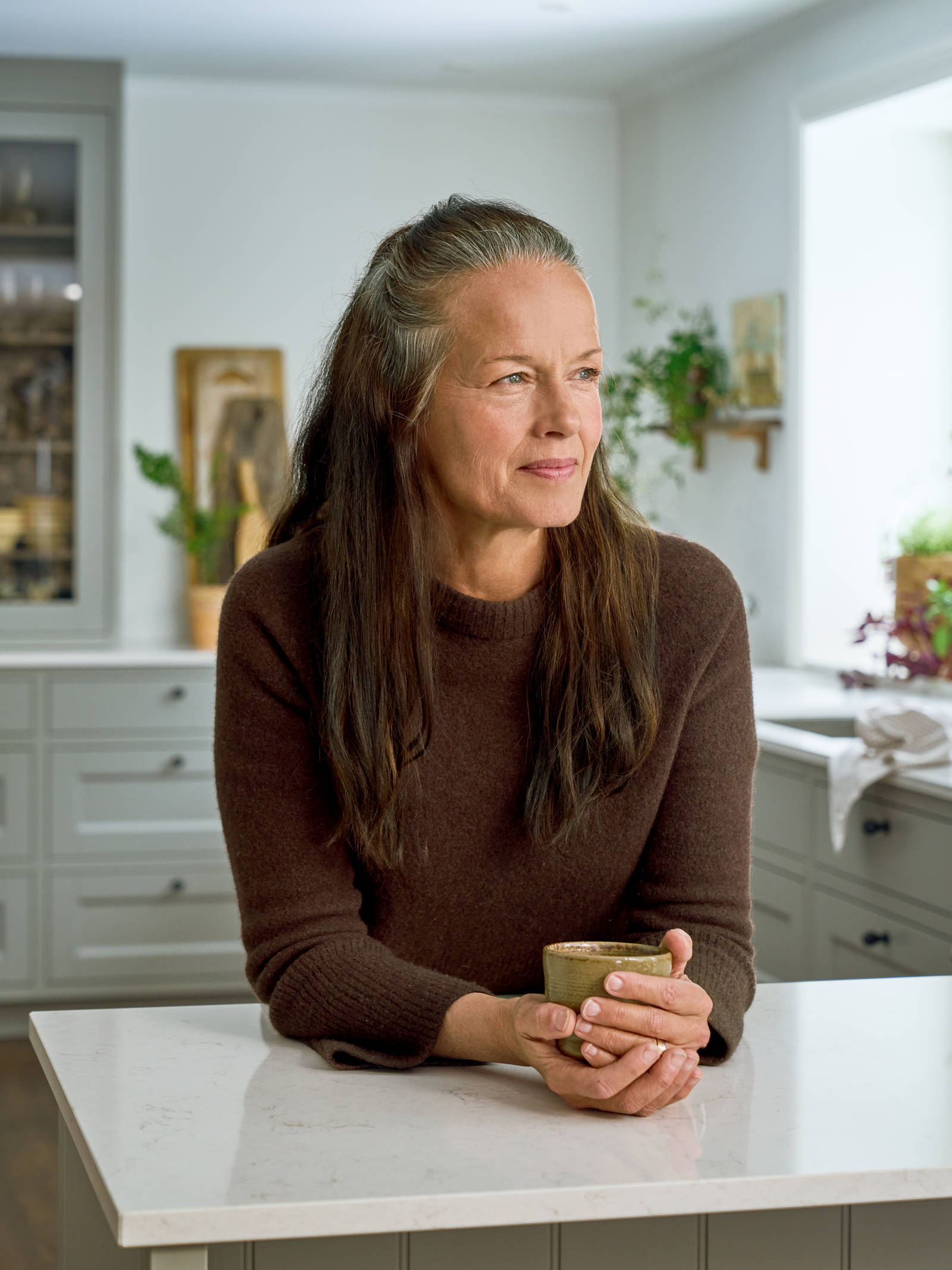 Malin Berghagen lutar sig mot käksbänken i sitt kök från Marbodal, lantliga Fagerö i kulören Frö.