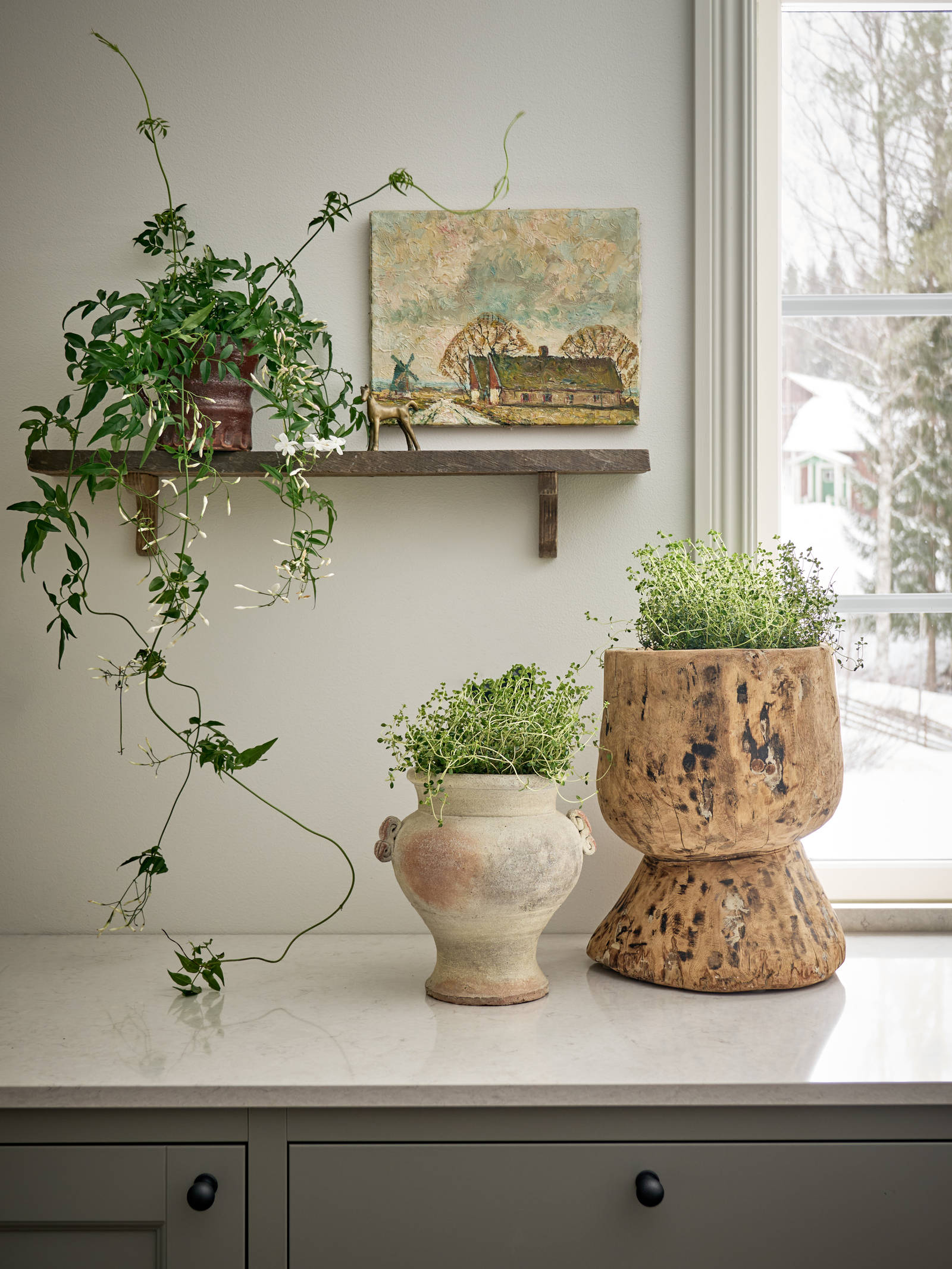 En kökshylla i Malin Berghagens kök med grönska.