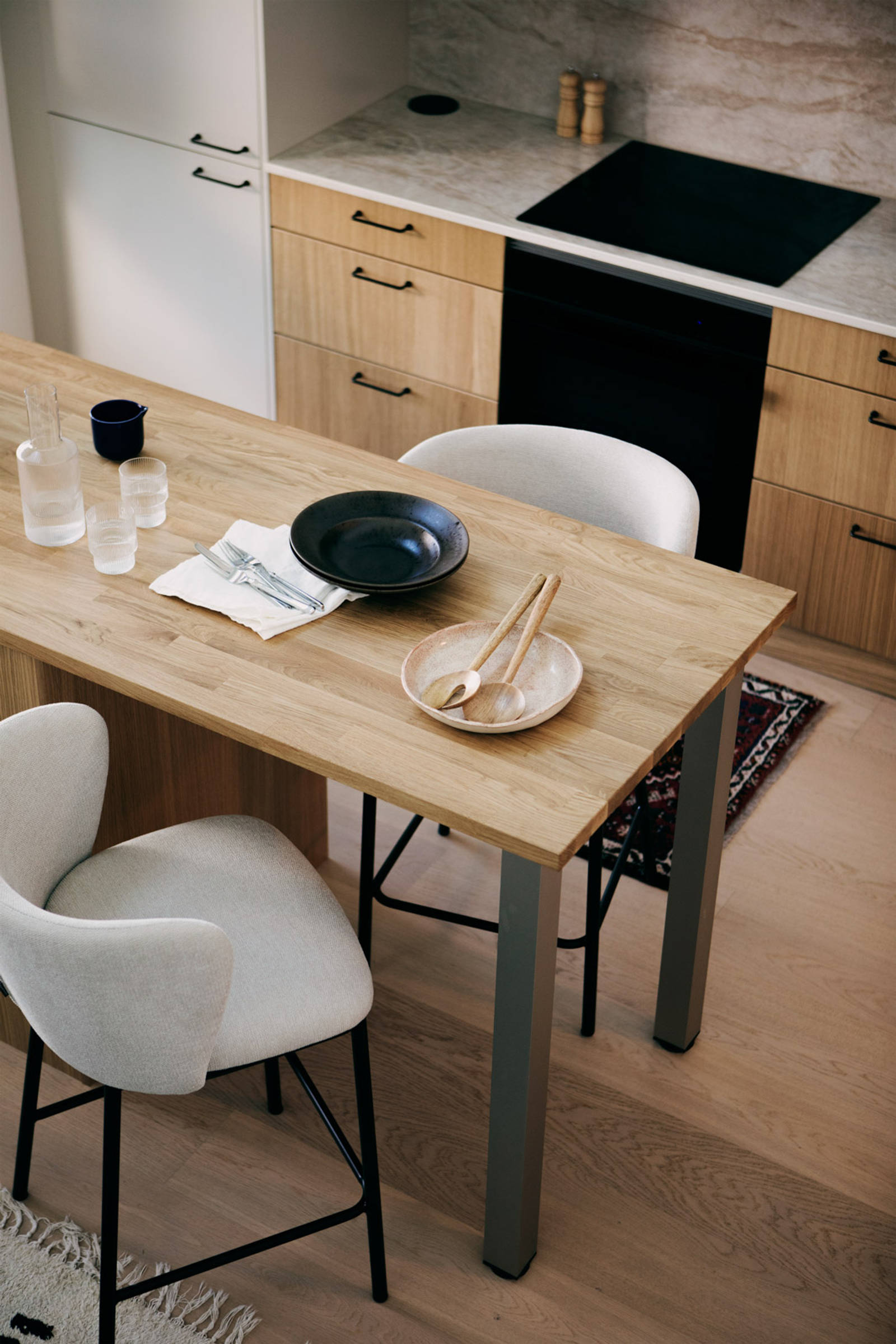 Keittiössä puiset alakaapit, yhteensopivat seinähyllyt ja valkoiset yläkaapit sisäänrakennetulla liesituulettimella