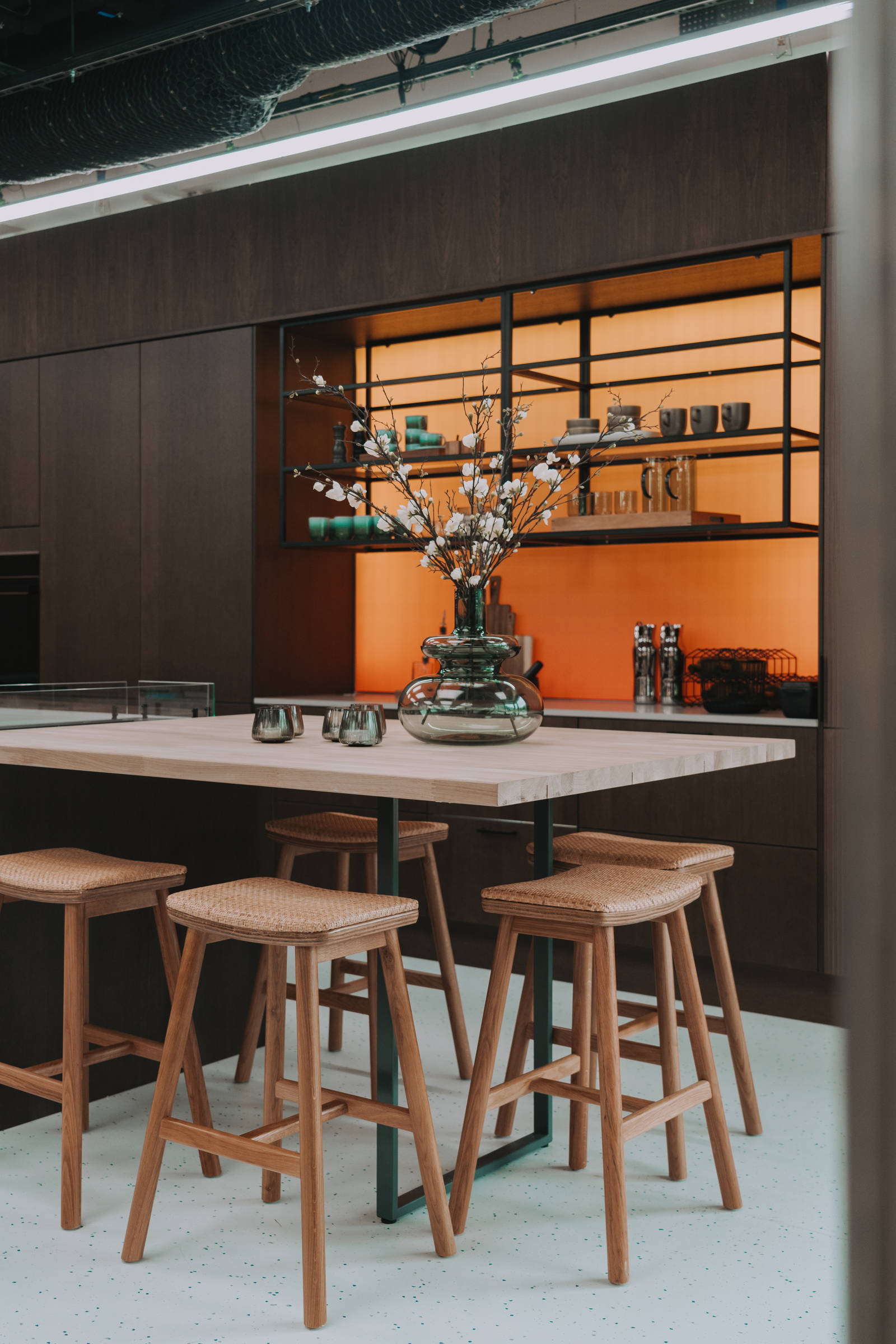 Kjøkken i modell Favn fra Sigdal i lekker eikefinér, som er beiset i fargen Nøtt, kjøkkenøya med barkrakker og åpne hyller i sort metallramme i God Morgen Norge studion sin