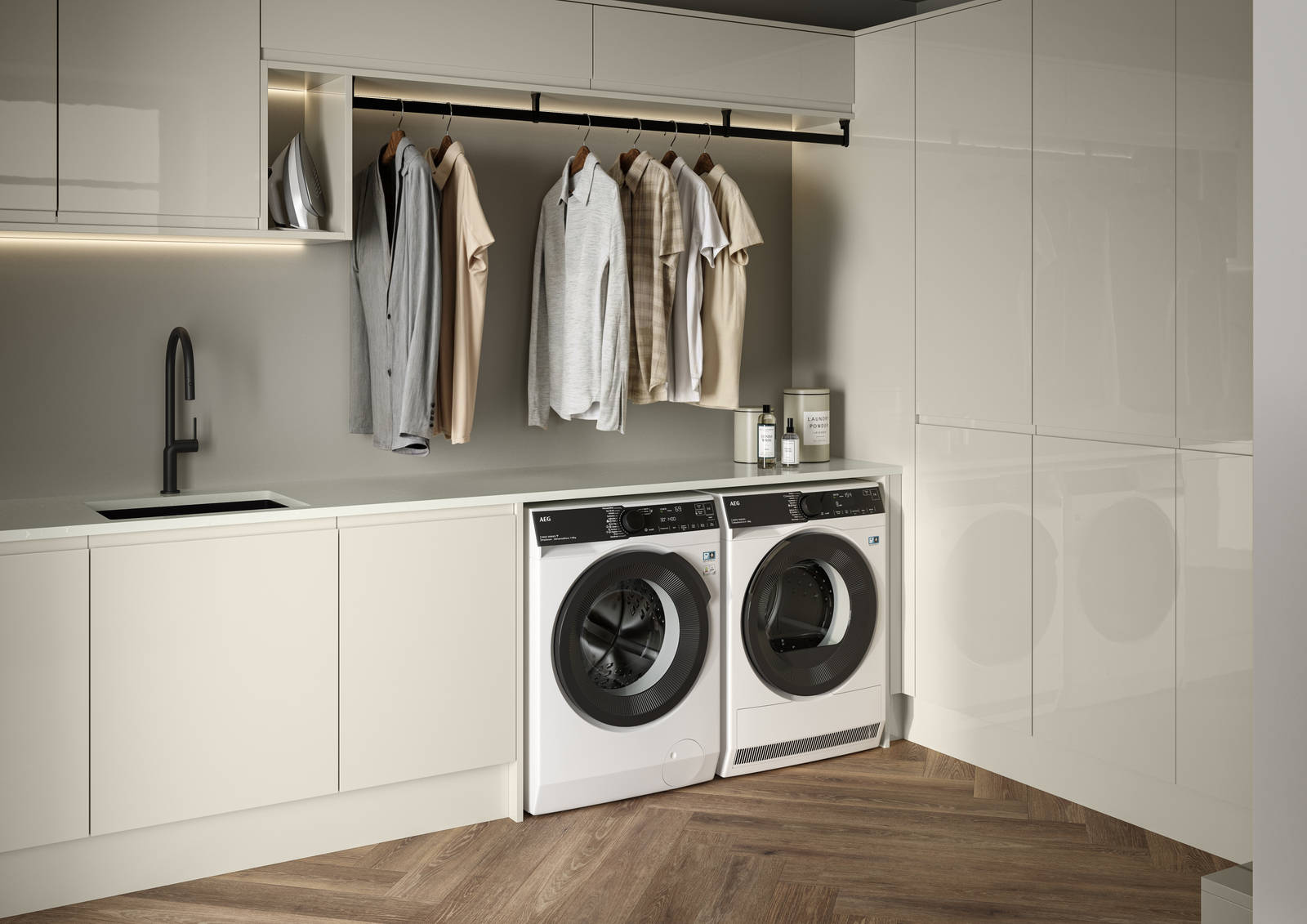 Contemporrary and elegant Luna Gloss Limestone kitchen with integrated washing machine and tumble dryer, tall cabinets, coat hanger under top cabinets and a black sink matched with black tap and Amtico smouldering oak parquet flooring.