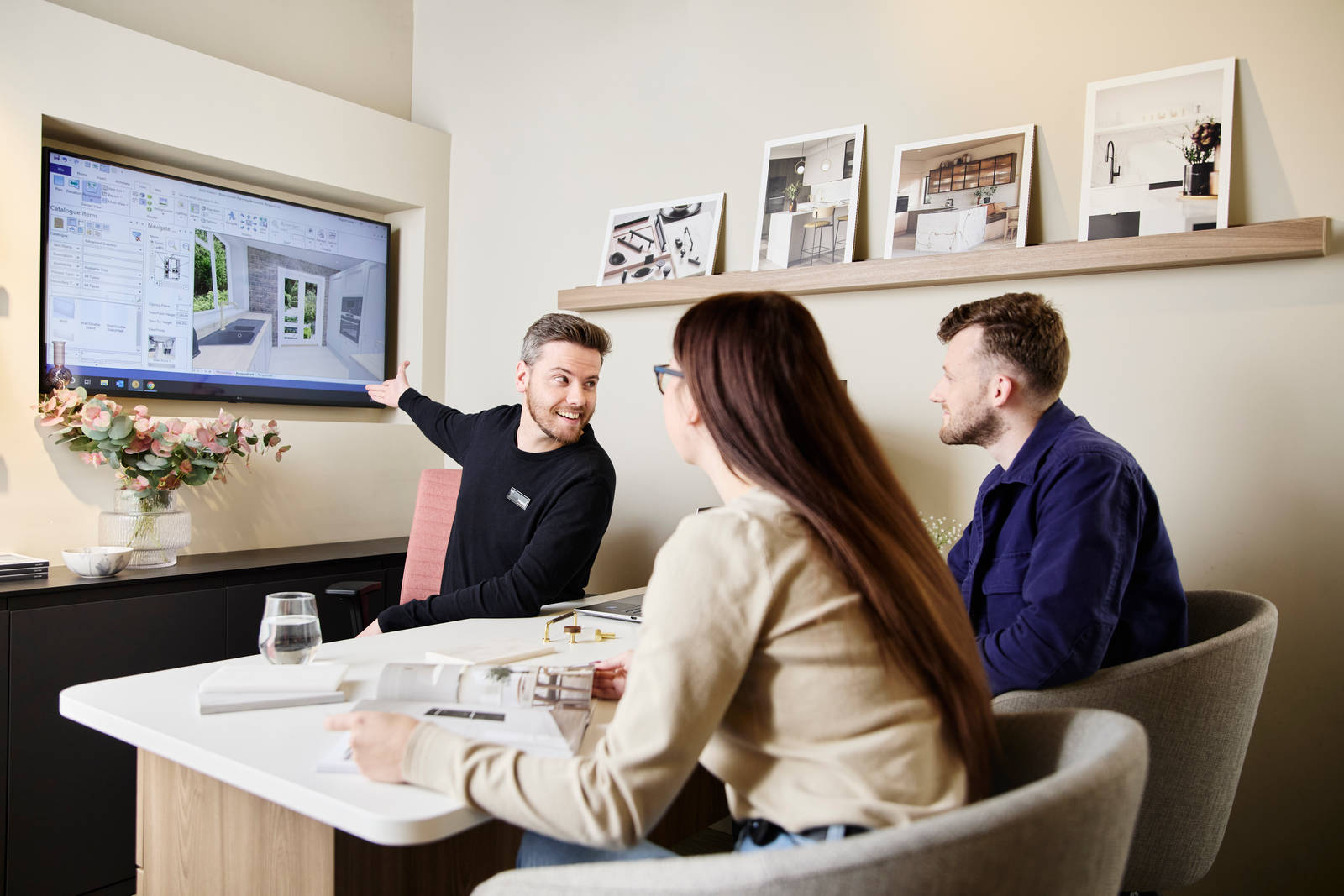 Magnet kitchen designer consulting customers in a Magnet store, showing a kitchen design.