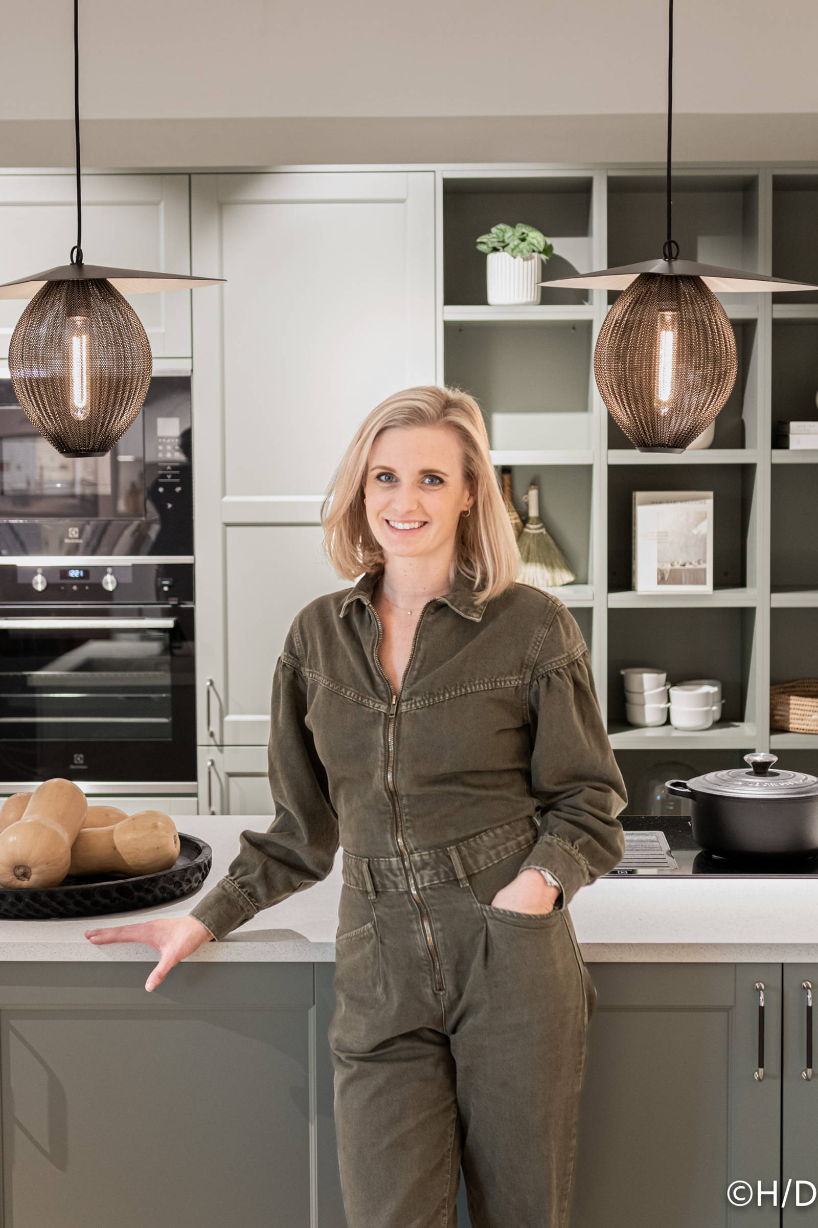 Köksdesigner Cassandra vid köksö i grönt shakerkök i Marbodals butik