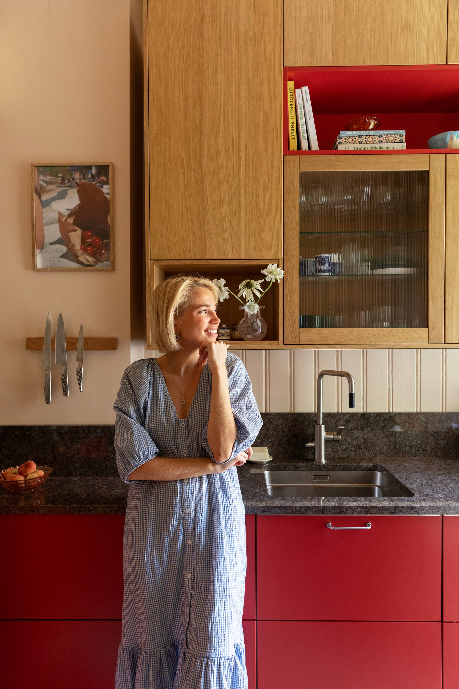 Thea Sofie Loch Næss  i Kirsebær-kjøkkenet sin fra Sigdal med Favn, eikefinér i beisfargen Natur og norsk naturstein benkeplate.