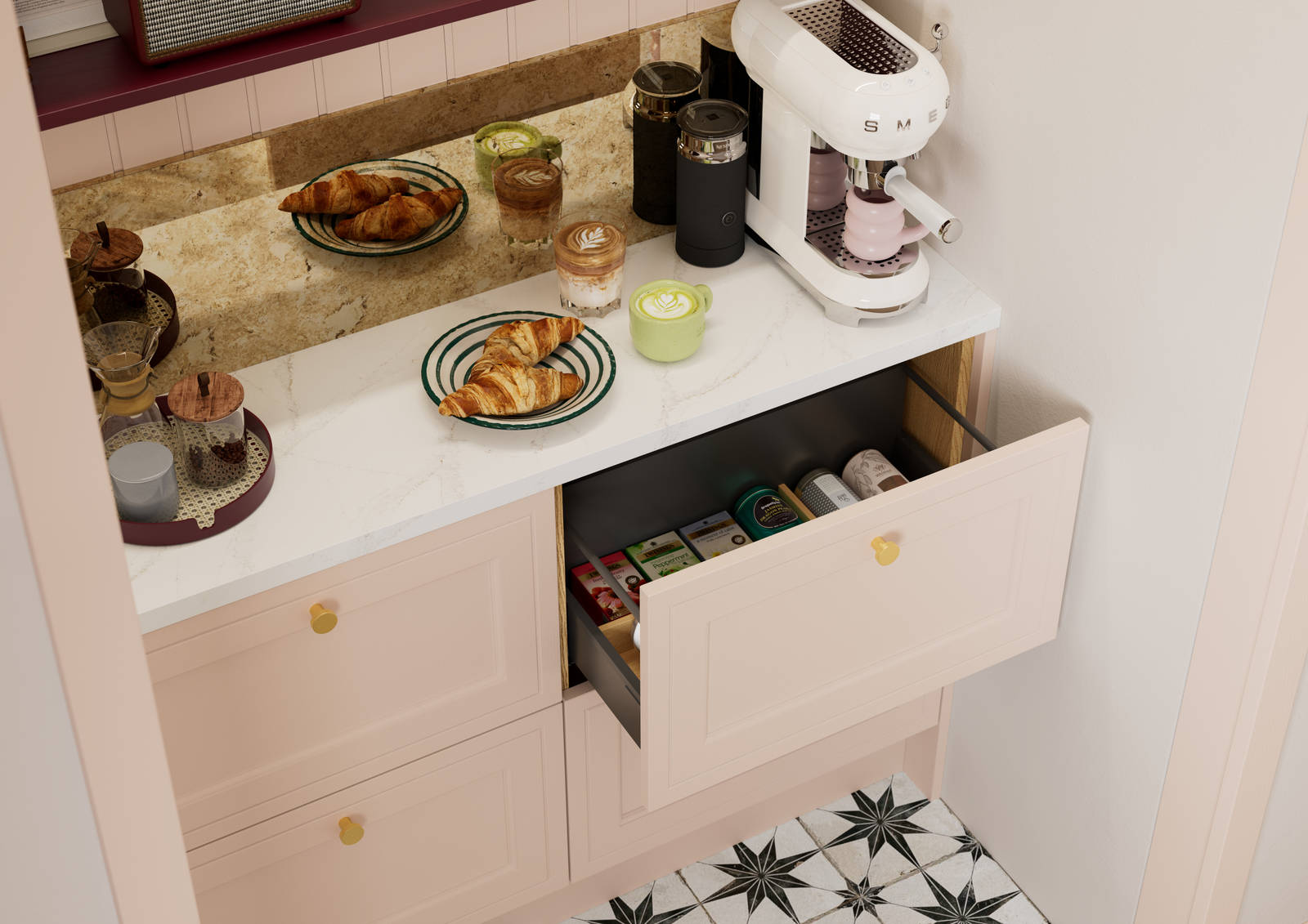 Opened drawer of teas in painted wood grain Shaker style Bewdley cabinets in light pink shade Chalk Blush, with marbled worktop, brass knobs and Smeg coffee machine on countertop.