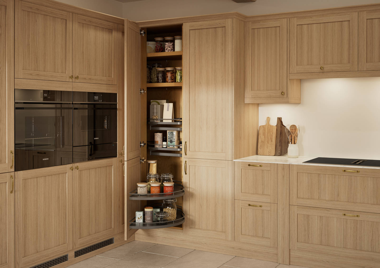 Traditional premium contemporary Shaker kitchen Ambleside in oak with brass knobs and handles, built-in ovens in tall cabinetry, opened tall corner cabinet with oak shelves and pull-out carousel.