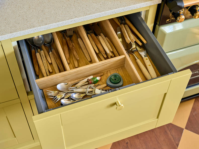 Åpnet kjøkkenskuff med bestikkinlegg i tre