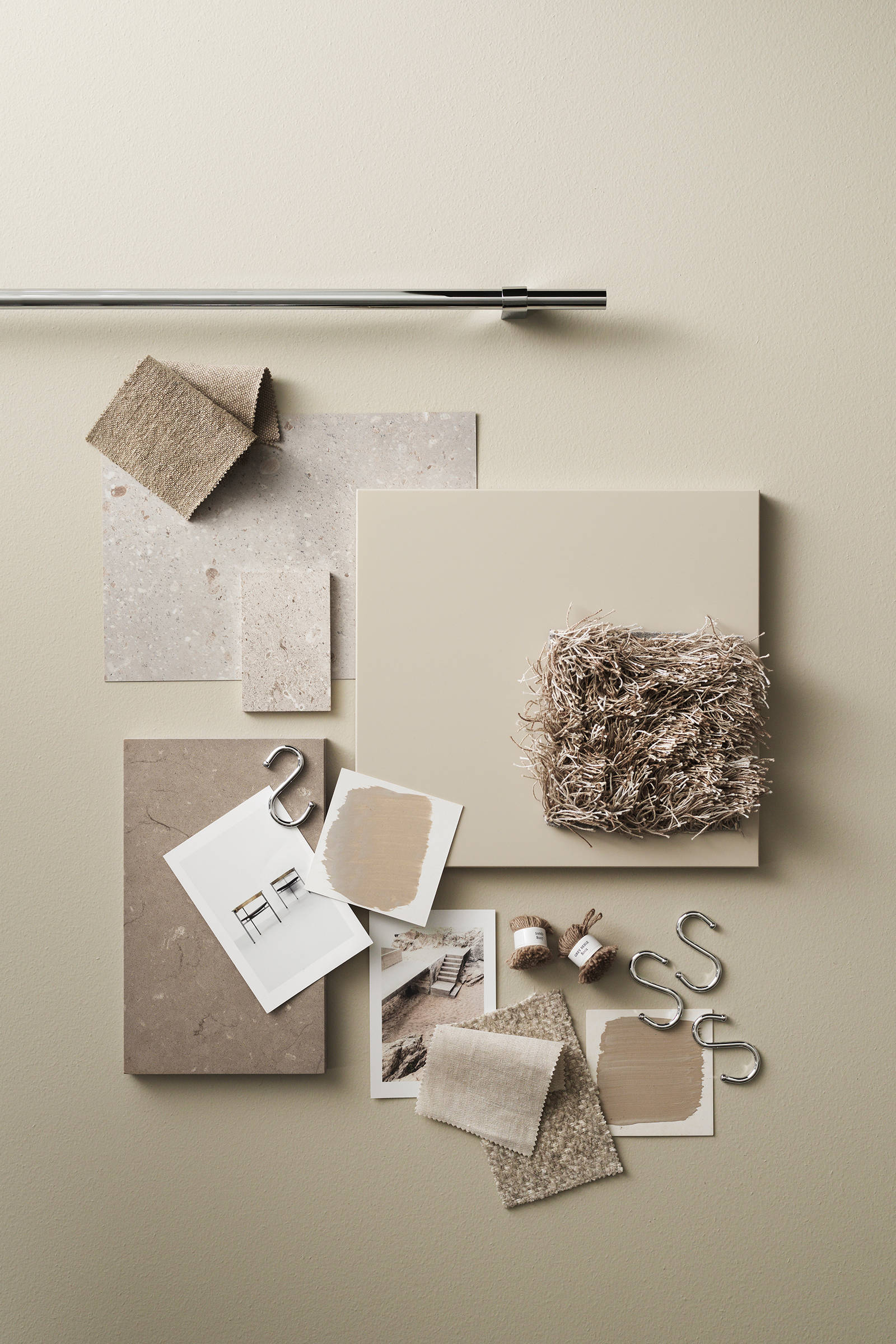 Moodboard med beige slät kökslucka, redskapsstång i rostfritt stål, jute och naturmaterial, grå bänkskiva