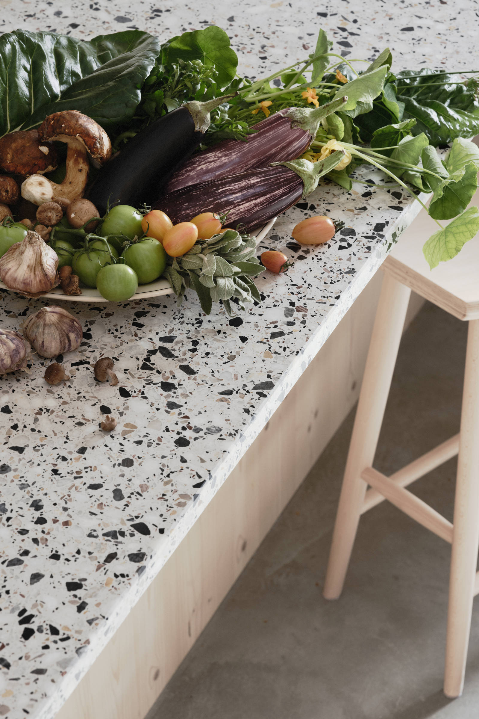 Köksö i ljust trä med terrazzo-bänkskiva och  matchande stänkskydd, vitrinskåp med räfflat glas i Edd Ruchtons Grand design kök i beige Arkitekt Plus-kök från Marbodal