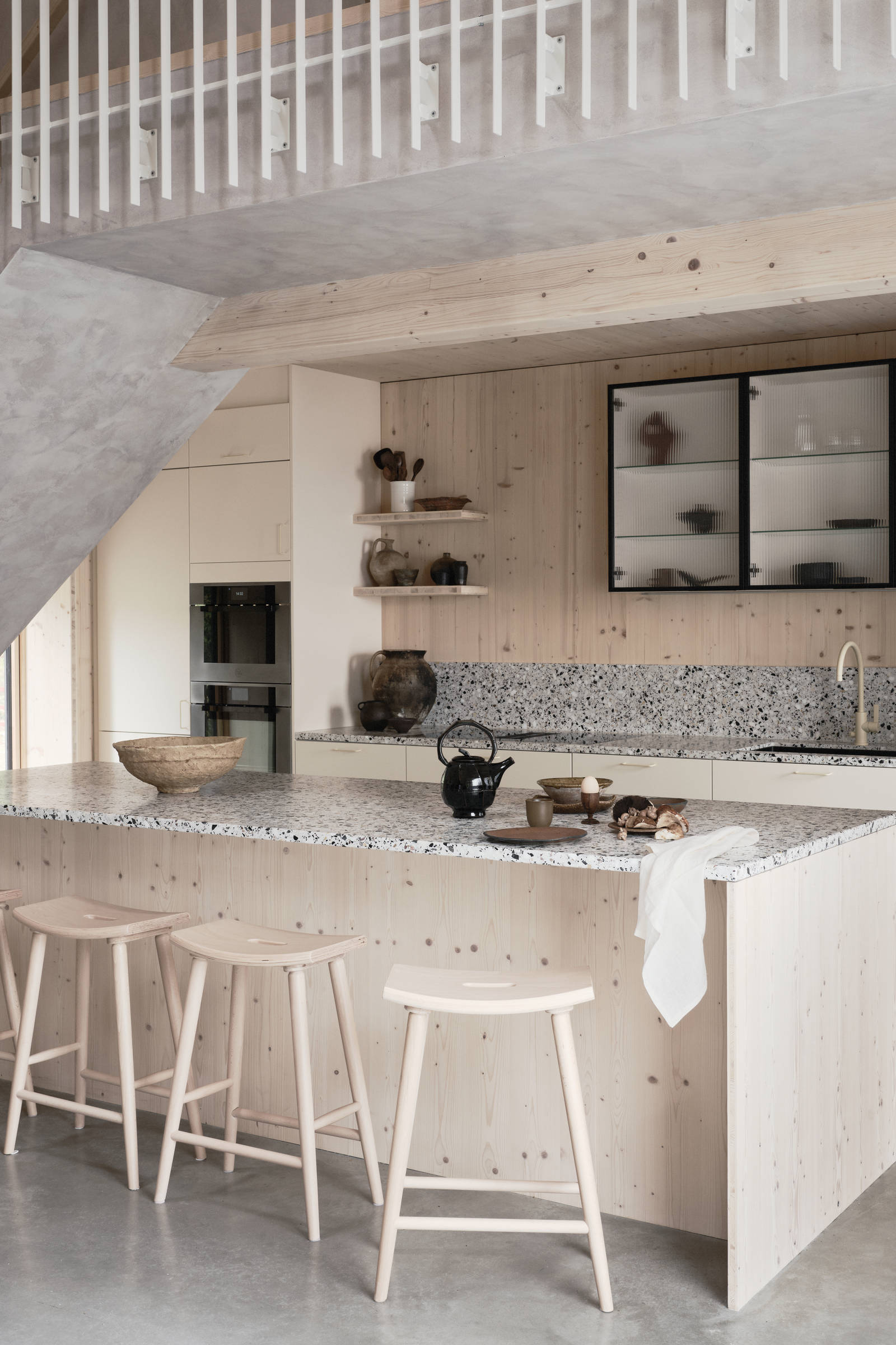 Köksö i ljust trä med terrazzo-bänkskiva och  matchande stänkskydd, vitrinskåp med räfflat glas i Edd Ruchtons Grand design kök i beige Arkitekt Plus-kök från Marbodal