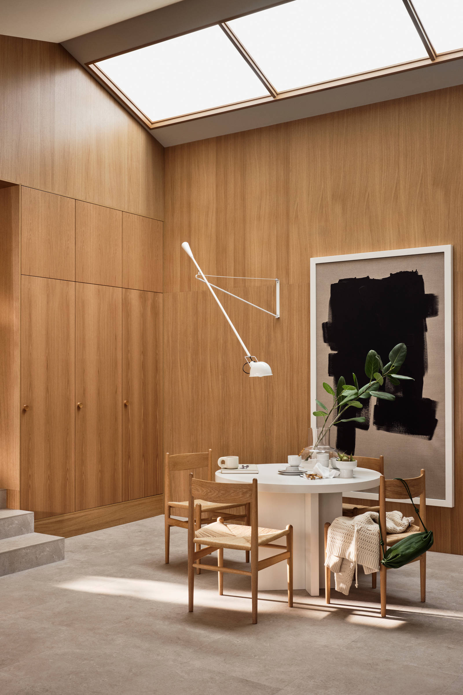 Jubilæumskøkken fra INVITA med elegant træfinér eg, matchende vægpanel og skaber inspireret av 1970'erne, hvid bord med stoler i tre
