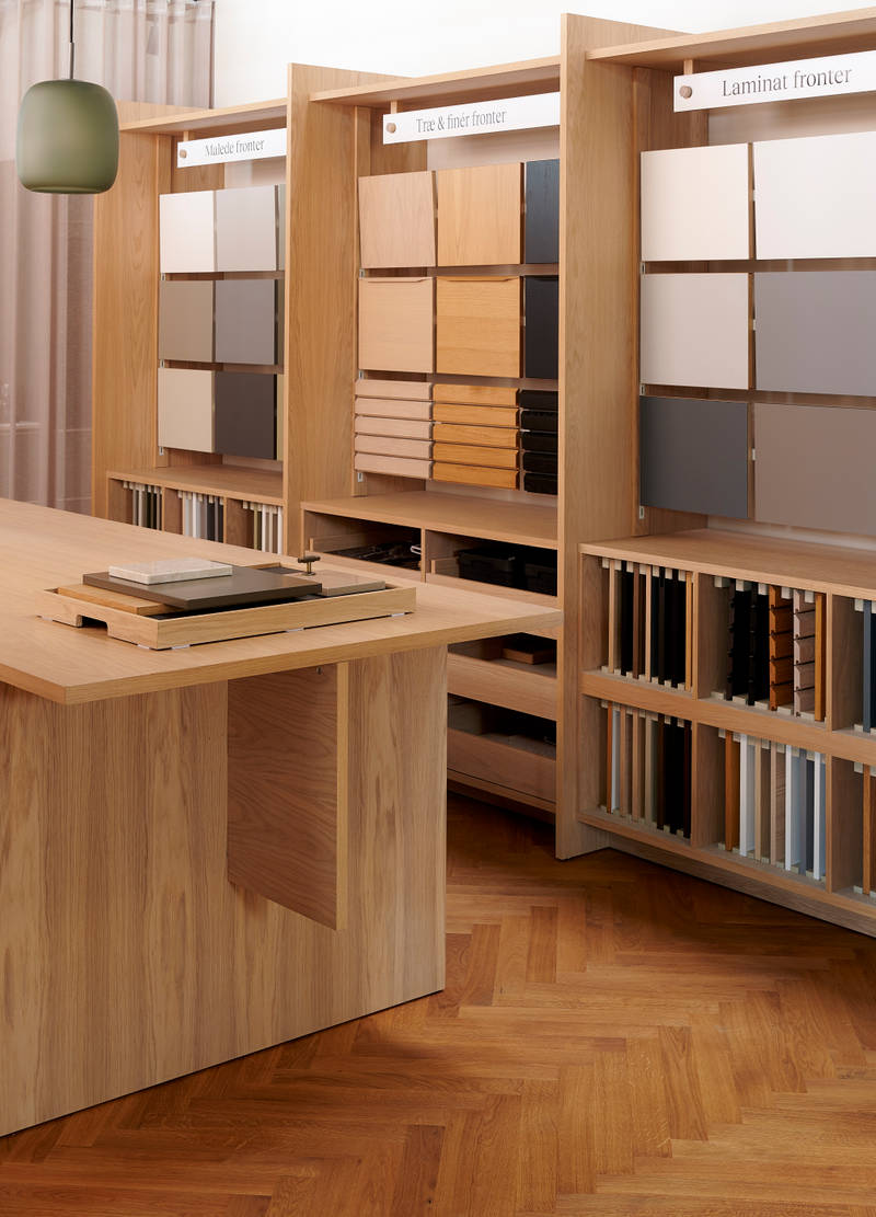 Væghylder med prøver af køkkenlåger i forskellige stilarter og farver i INVITAs butik