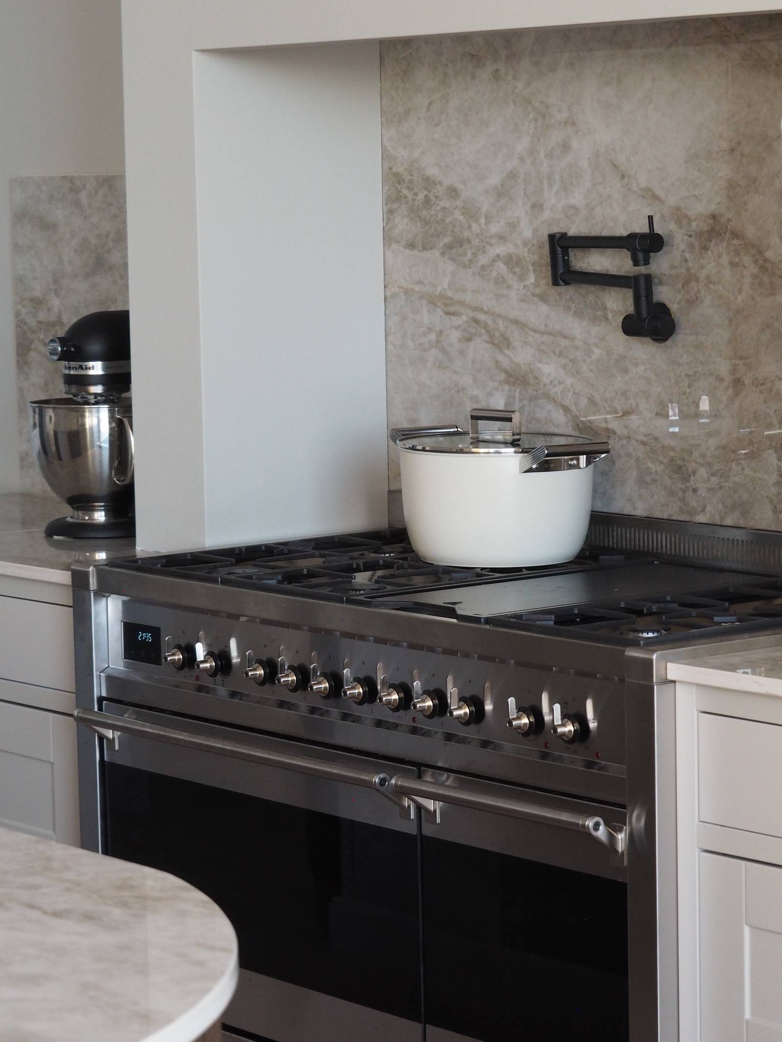 Komfur fra Smeg i rustfri stål med en hvid gryde på