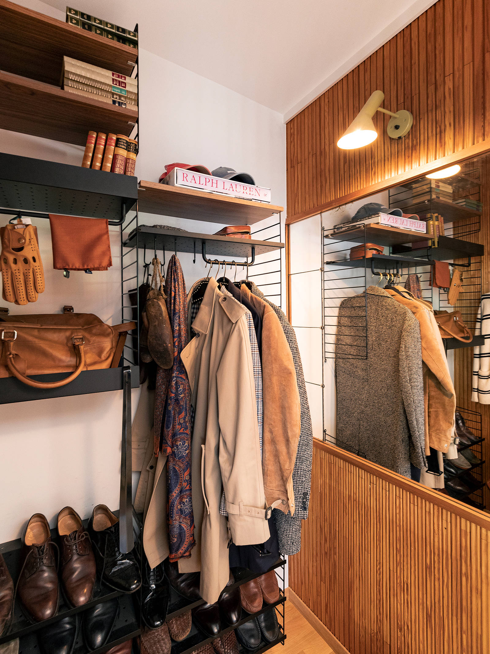 Teaktræpanelerne på væggene i entréen og garderobe-nichen danner et originalt bagtæppe for en maskulin indretning med fokus på skandinaviske designklassikere i teaktræ, valnød og palisander