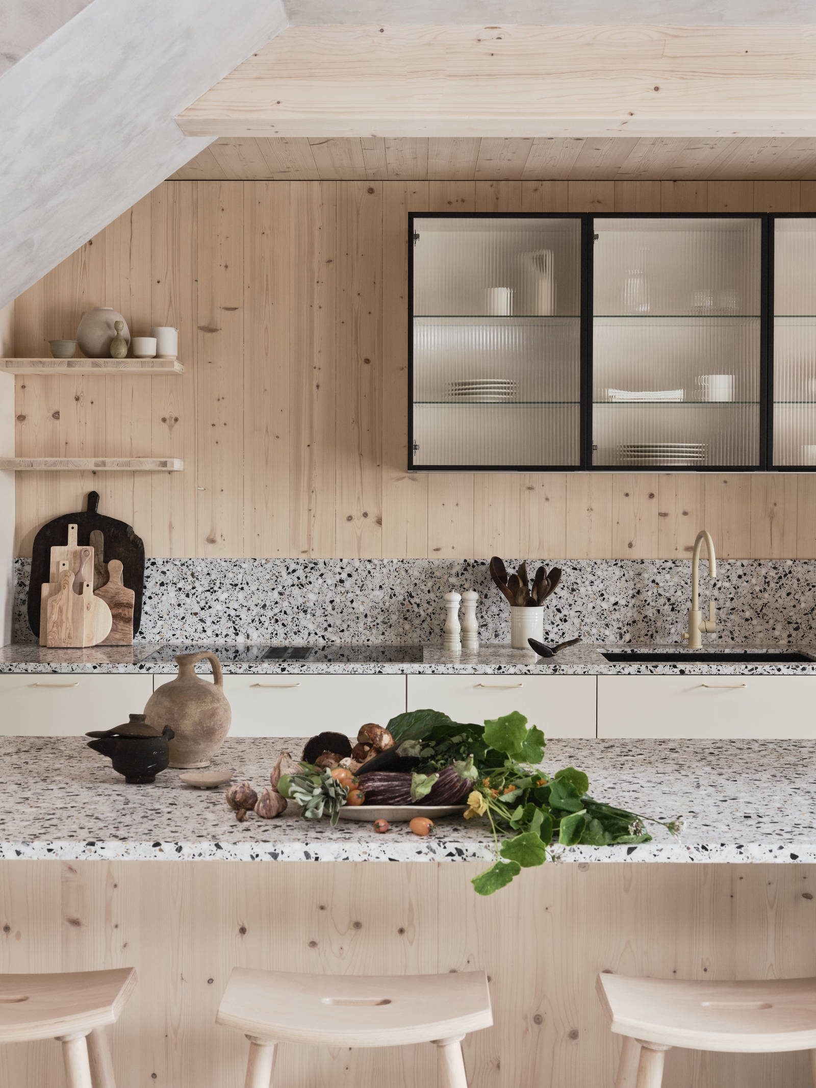 Köksö i ljust trä med terrazzo-bänkskiva och  matchande stänkskydd, vitrinskåp med räfflat glas i Edd Ruchtons Grand design kök i beige Arkitekt Plus-kök från Marbodal