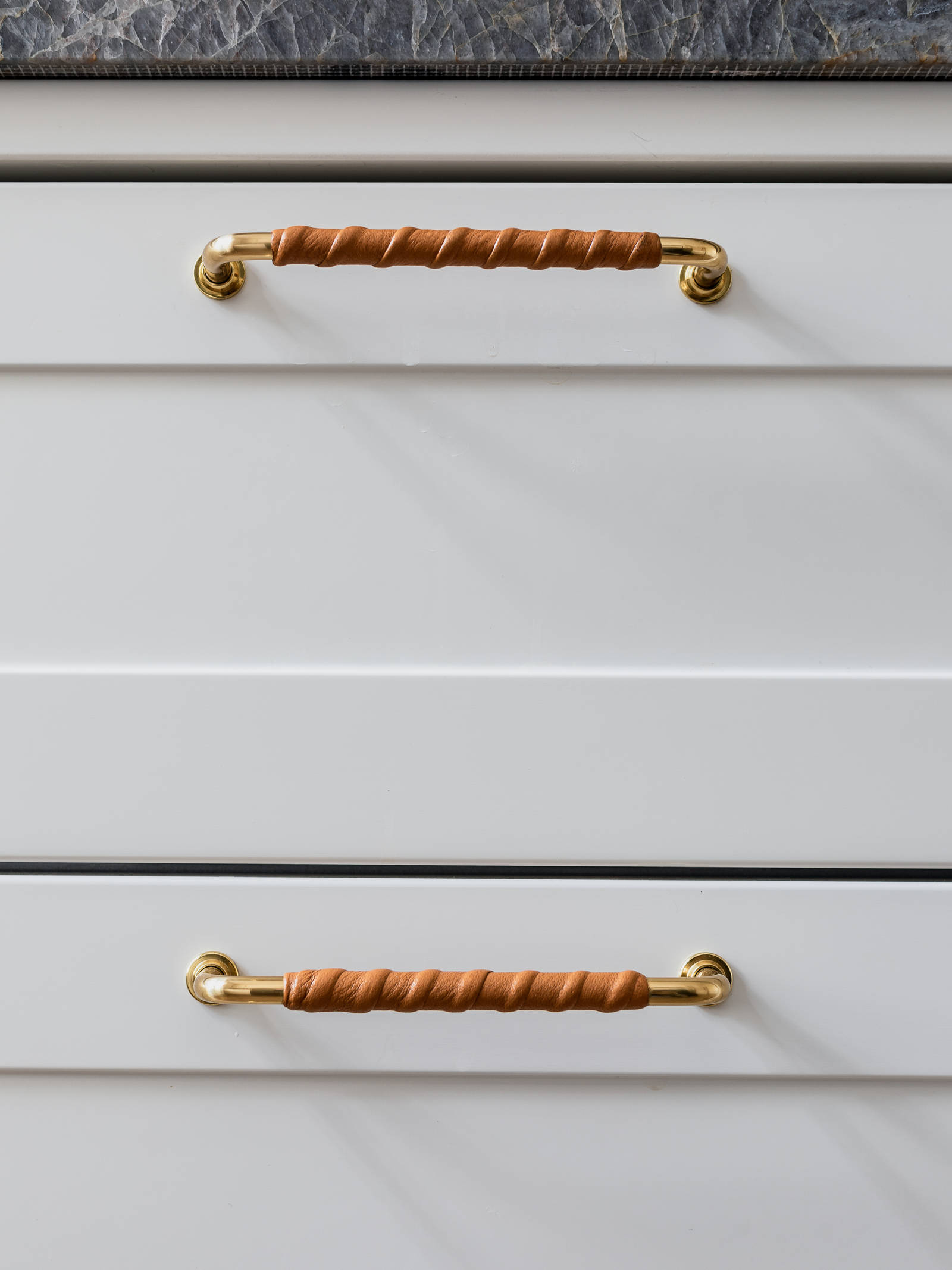 Køkkenet har messinggreb med cognacfarvet læder.