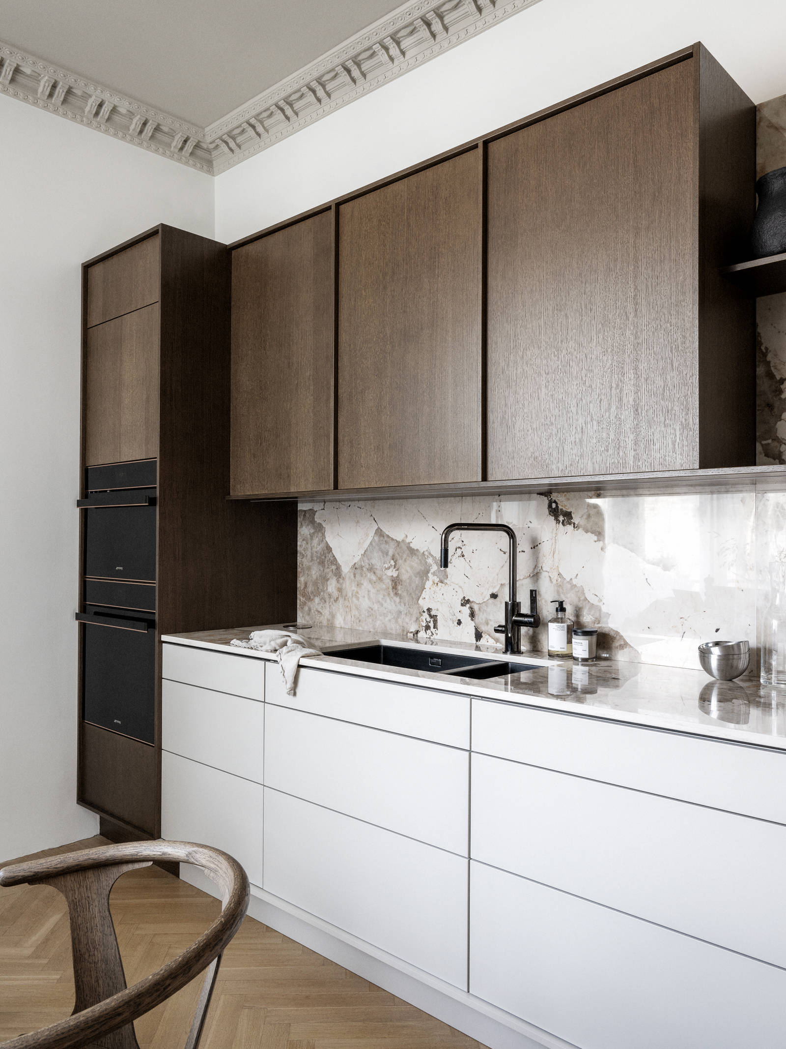 Kök med kombination av köksbänk i beige Arkitekt Plus Sand med överskåp och högskåp i Signatur Ekbacken fanerad eklucka i brunbets från Marbodal, bänkskiva och stänkskydd som matchar och öppna vägghyllor i brunbetsad ekfanér.