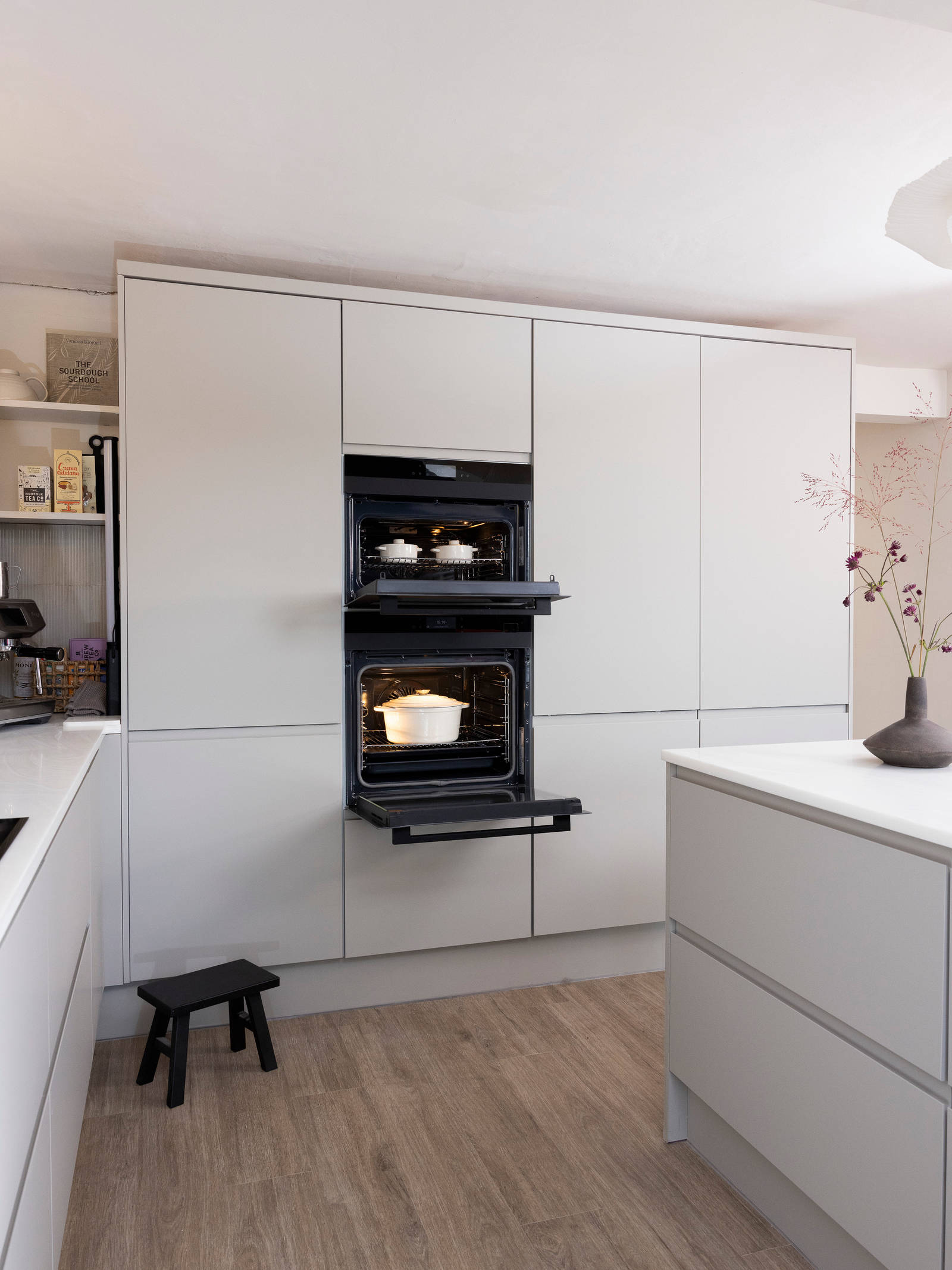 View of opened built-in ovens in the tall matt finish Luna kitchen cabinetry from Magnet in a neutral shade.