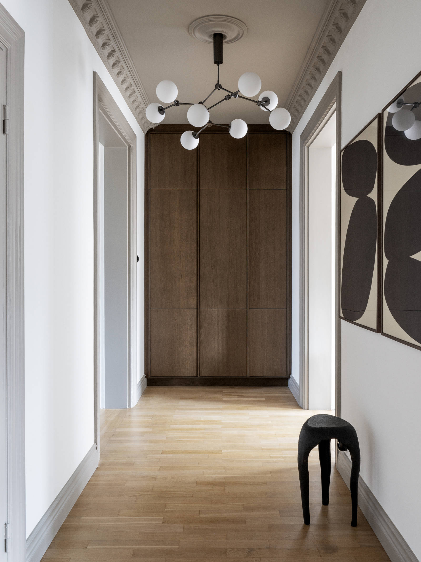 Høyskap i enden av korridoren, i Favn brunbeisede finerte eikedører, gir et enhetlig inntrykk i hele leiligheten.