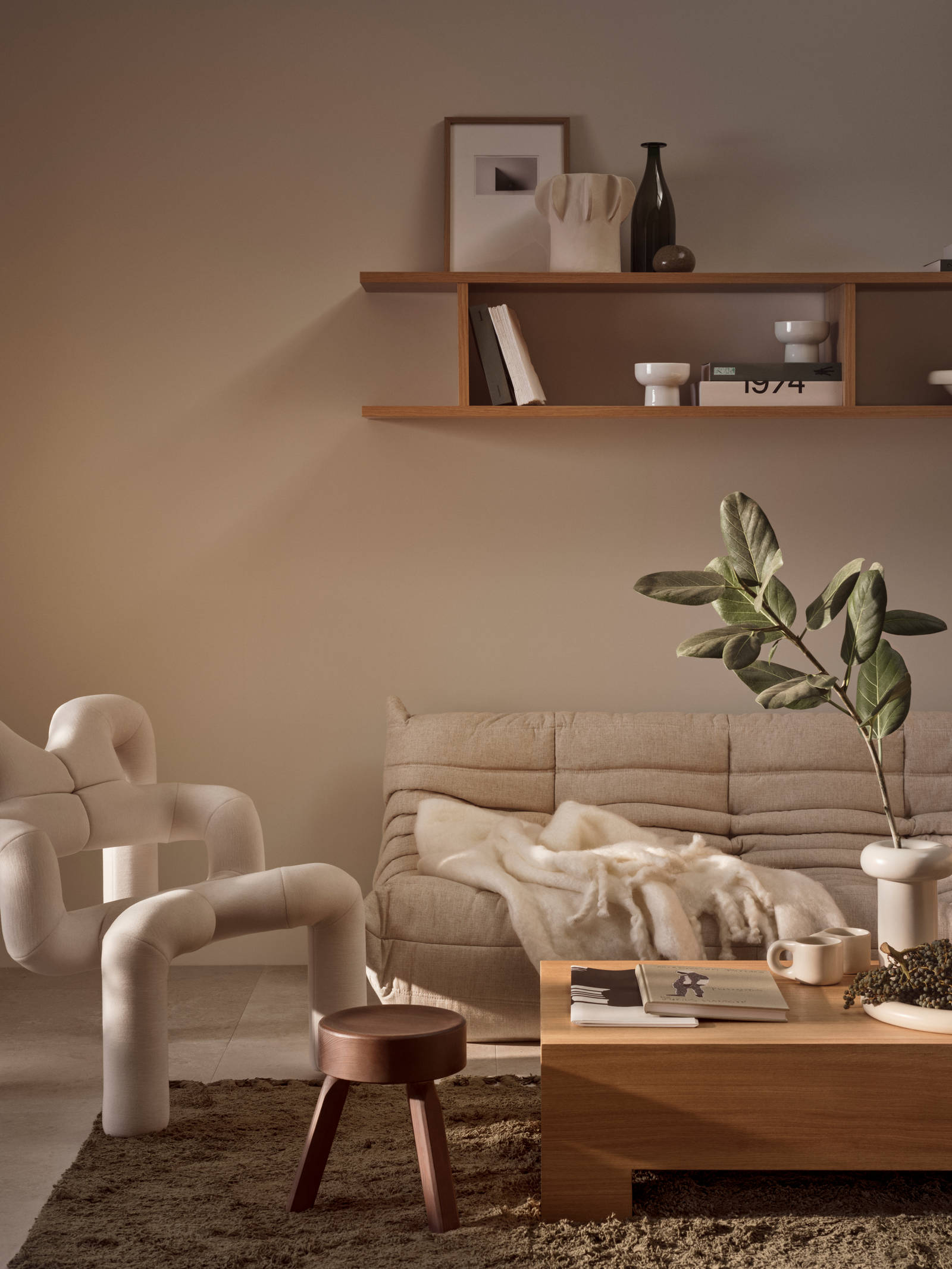 Stue med beige sofa og INVITA-kataloger på sofabordet i egetræ