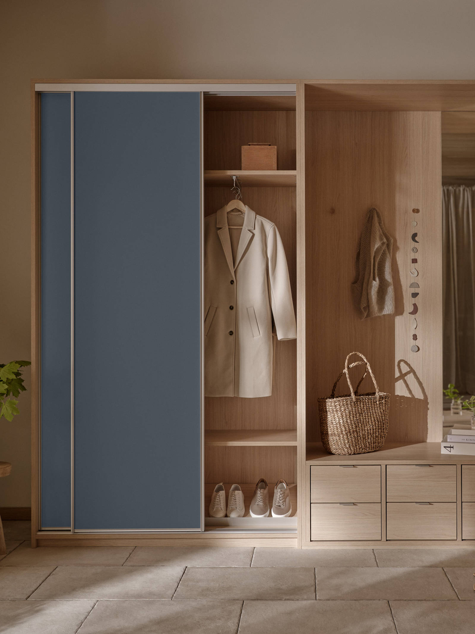 Mørk blå skyvedør i lys tre garderobeskap