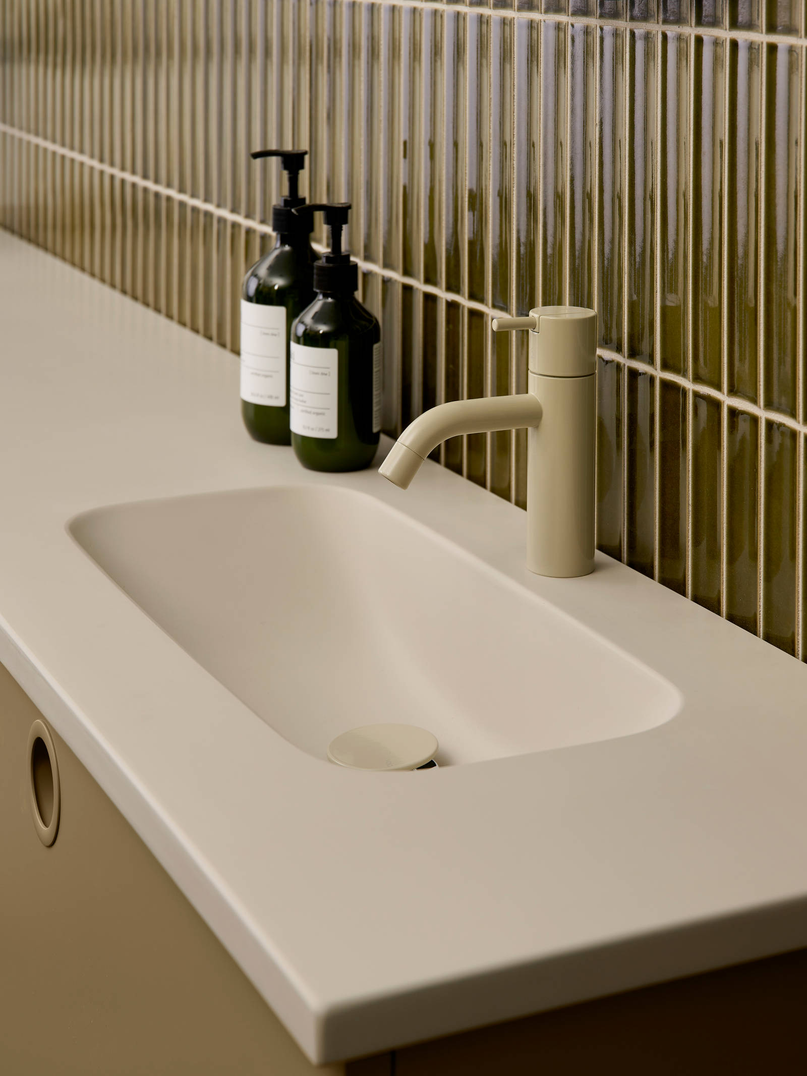 Nærbillede av vask og armatur i Jubilæumsbad fra INVITA med grønne skaber inspireret av 1970'erne, og grønne fliser