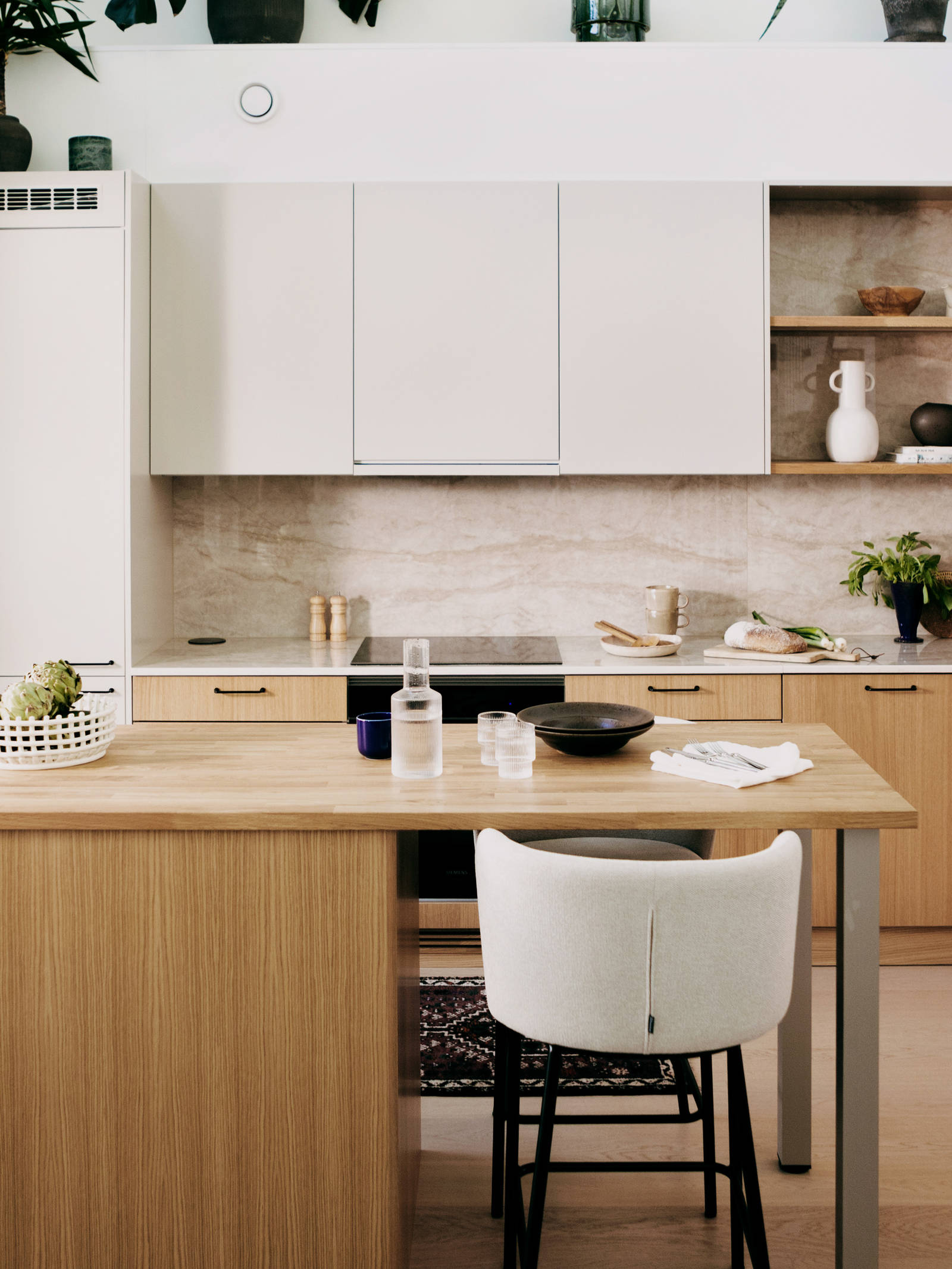 Keittiössä puiset alakaapit, yhteensopivat seinähyllyt ja valkoiset yläkaapit sisäänrakennetulla liesituulettimella