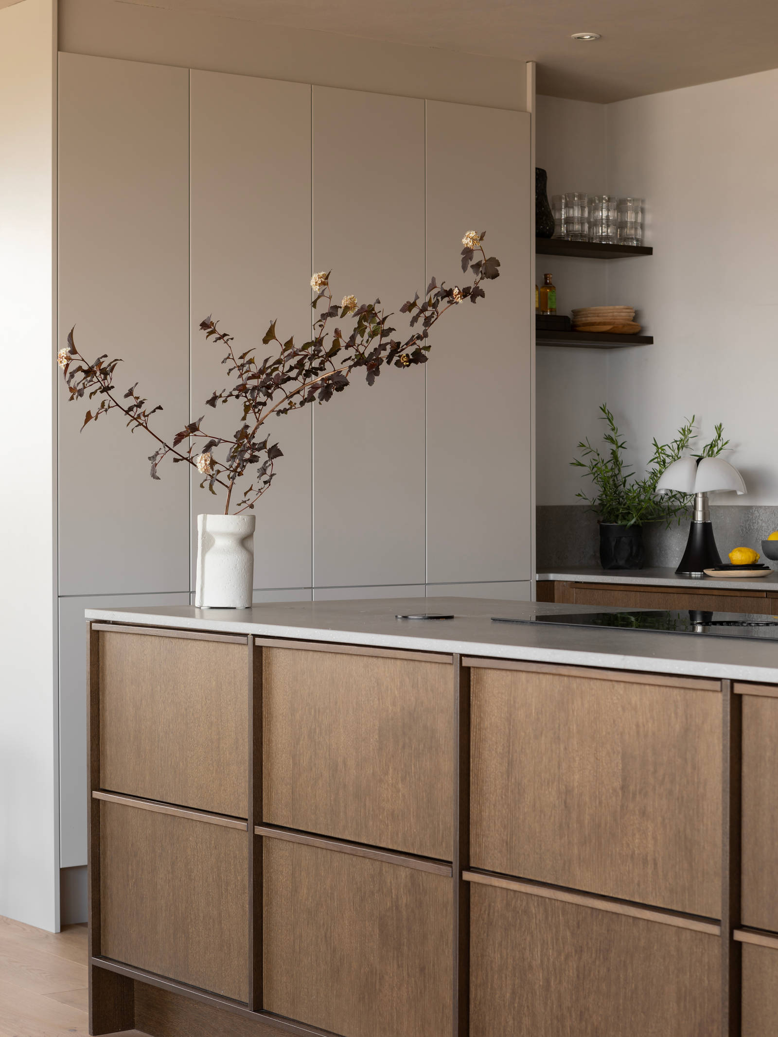 Køkkenø i brun egetræsfiner køkkenet Contours med matchende tre håndtag fra INVITA og beige højskabe Athena Sand