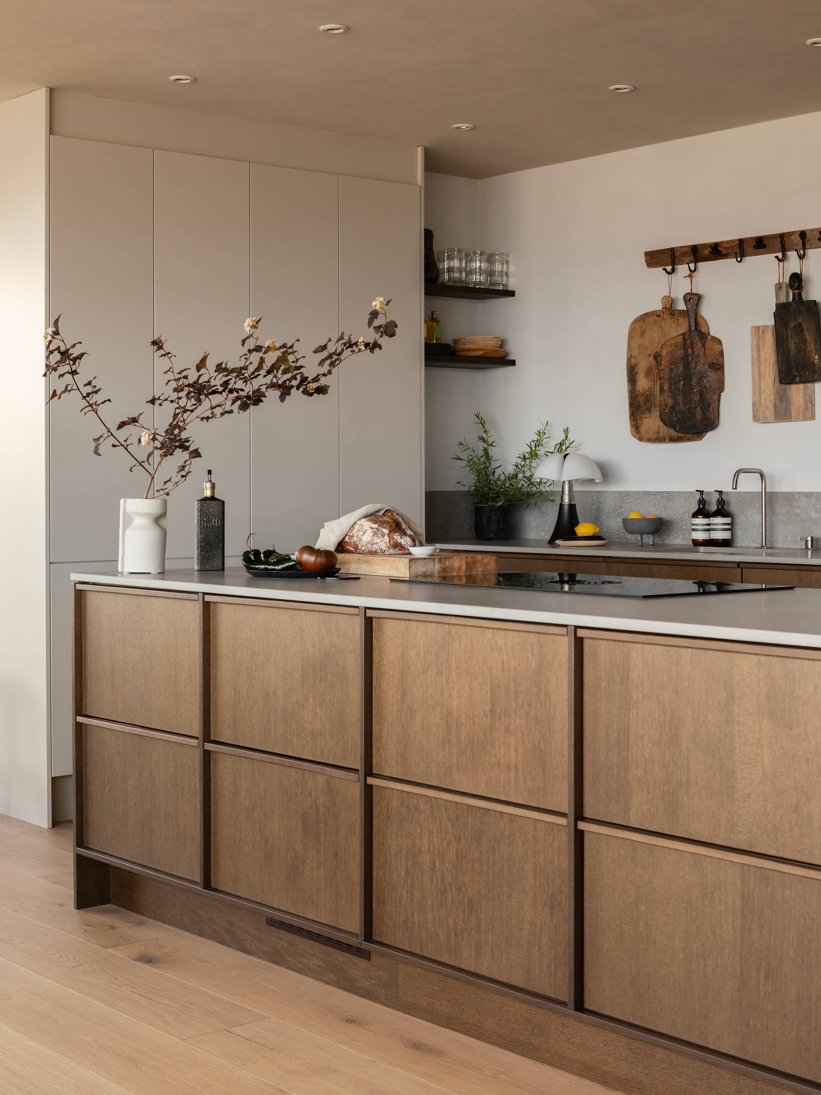 Køkkenø i brun egetræsfiner køkkenet Forever oak med matchende tre håndtag fra INVITA med beige højskabe Athena Sand