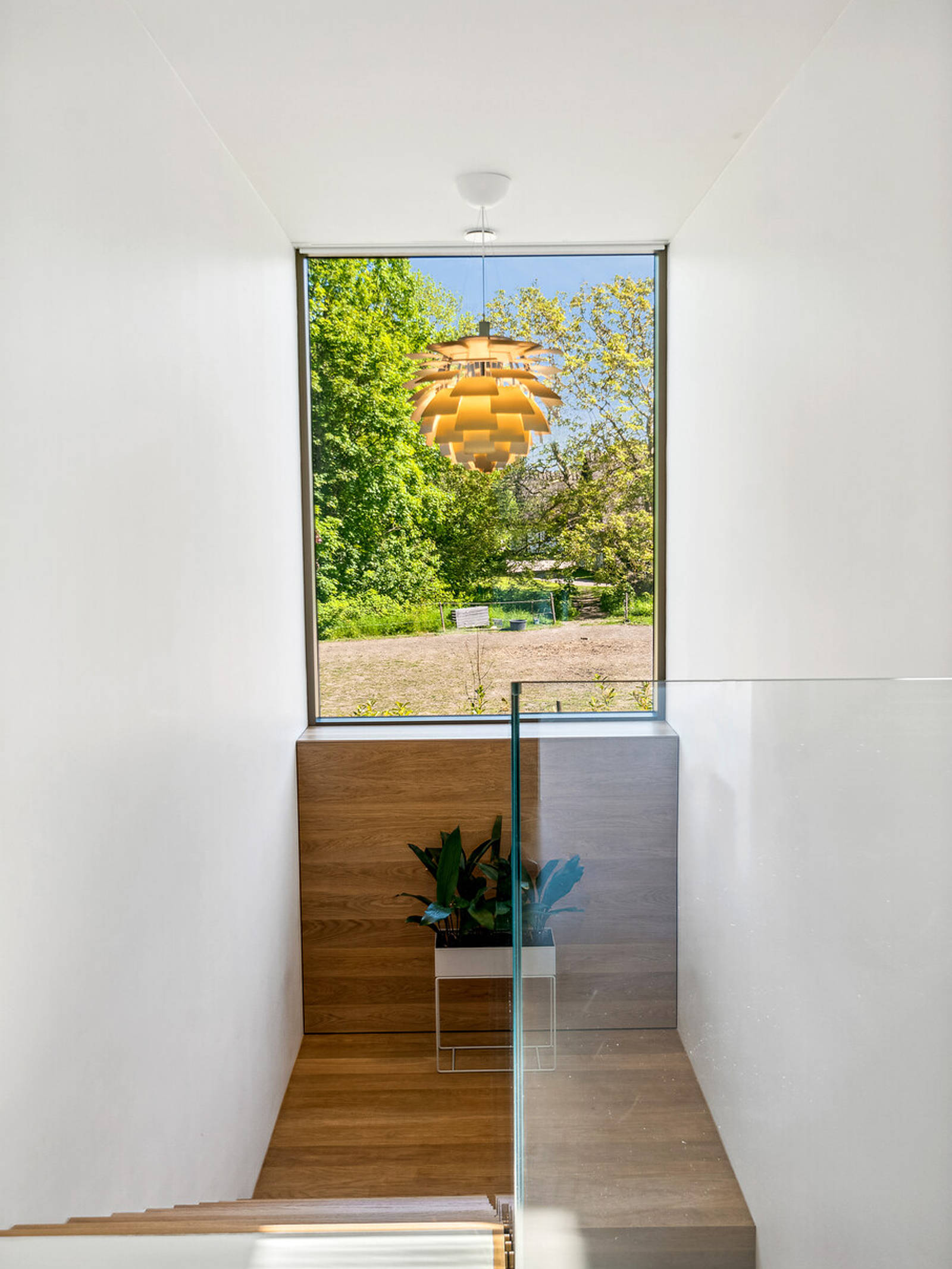 Trappe til husets kælder med kig til haven og dansk design i form af Koglen