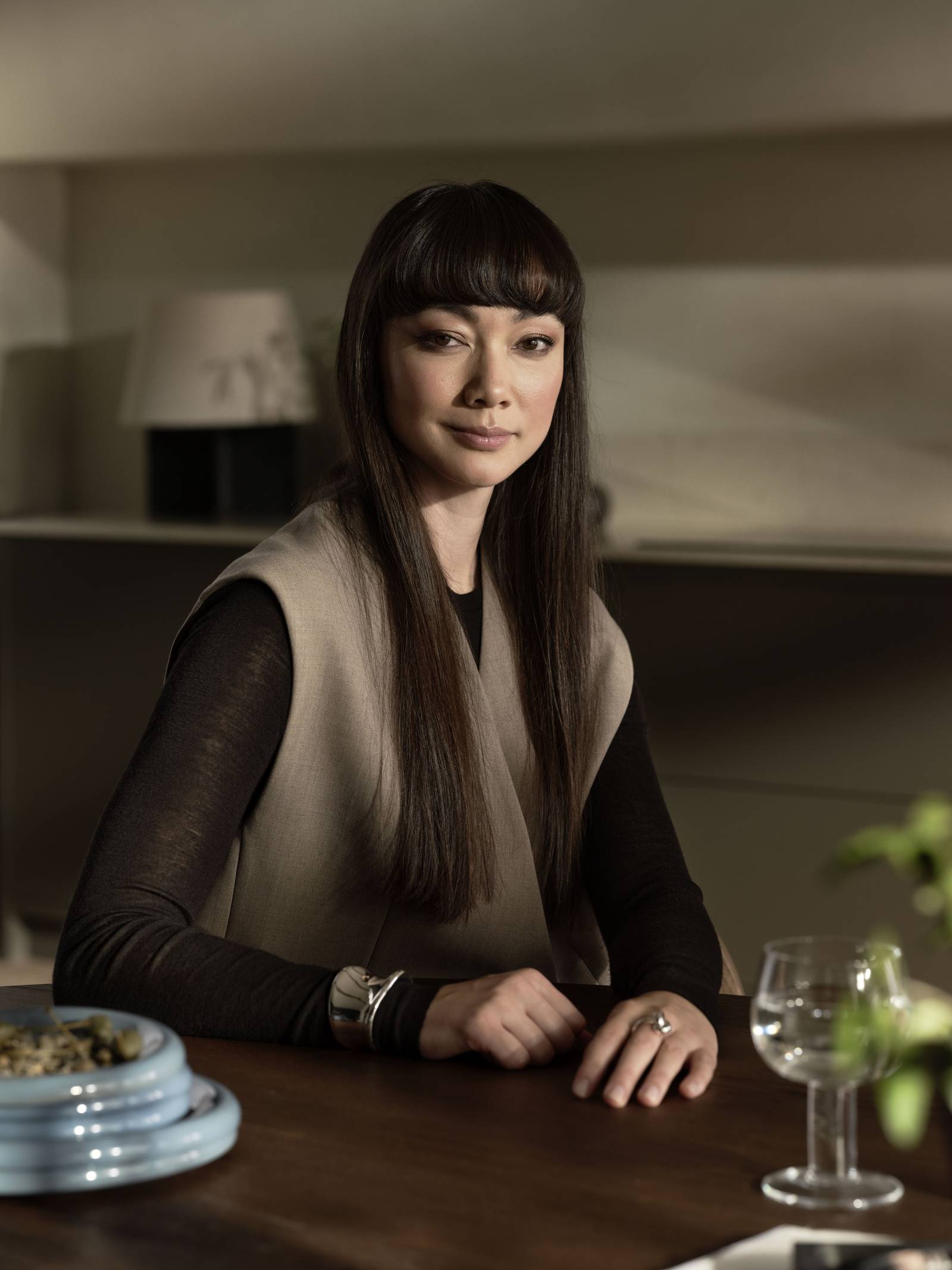 En närbild på en kvinna vid ett köksbord i ett kök från Marbodal i stilen Warm Minimalism.