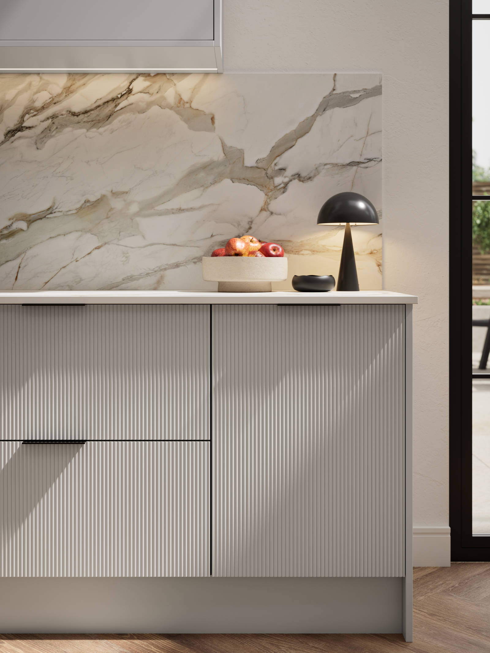 Fluted front kitchen Reed from Magnet in soft grey shade Dove Grey, with a marbled splashback and black handles, herringbone wood flooring.