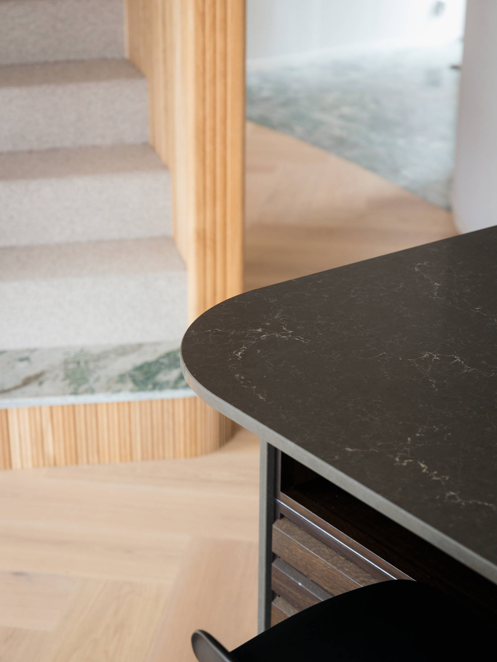 The kitchen island in smoked oak with rounded corners on the countertop.