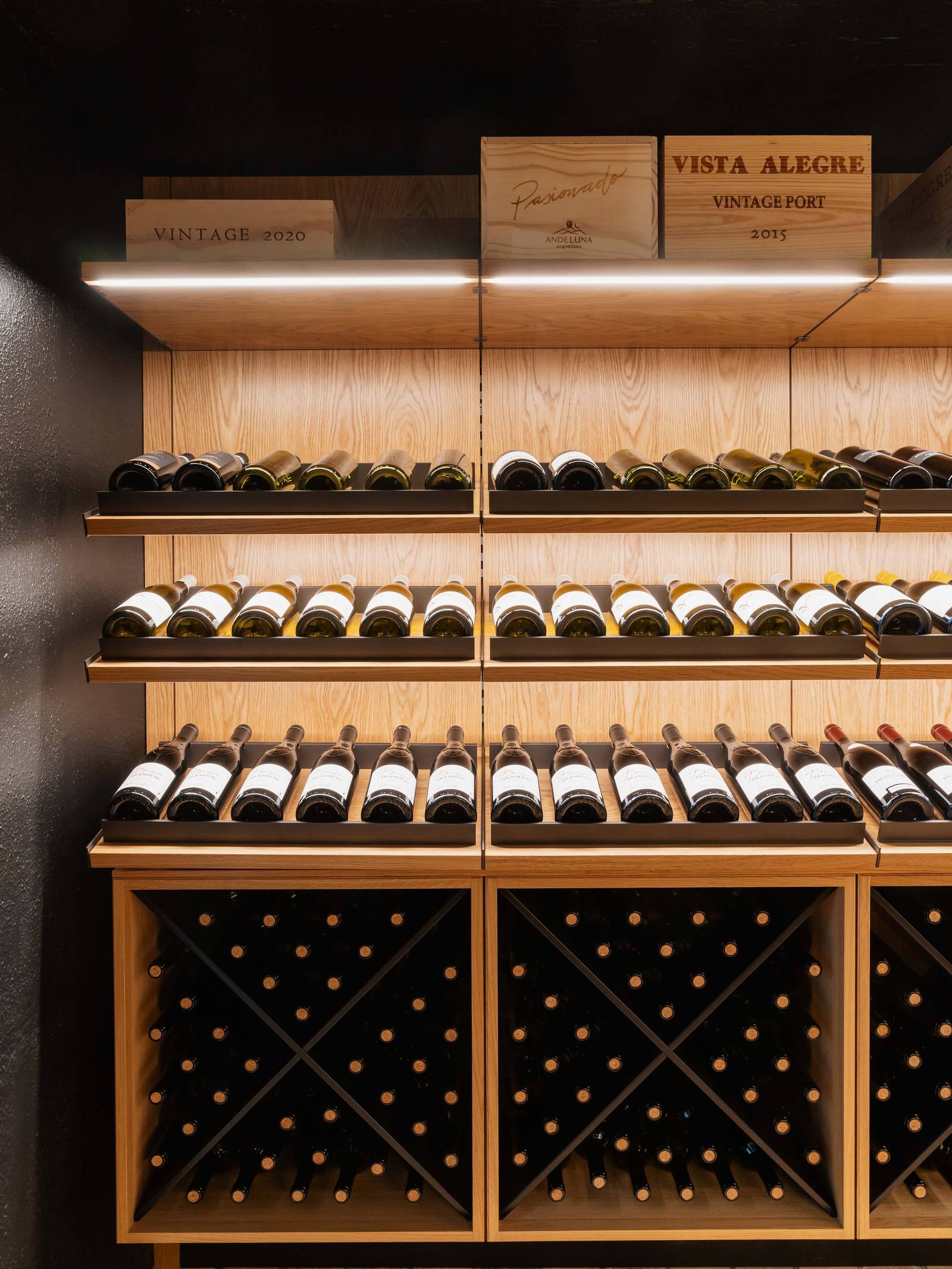 Vinkælder med skråtstillede hylder til vin on-display, vinkryds og opbevaring til vinkasser.