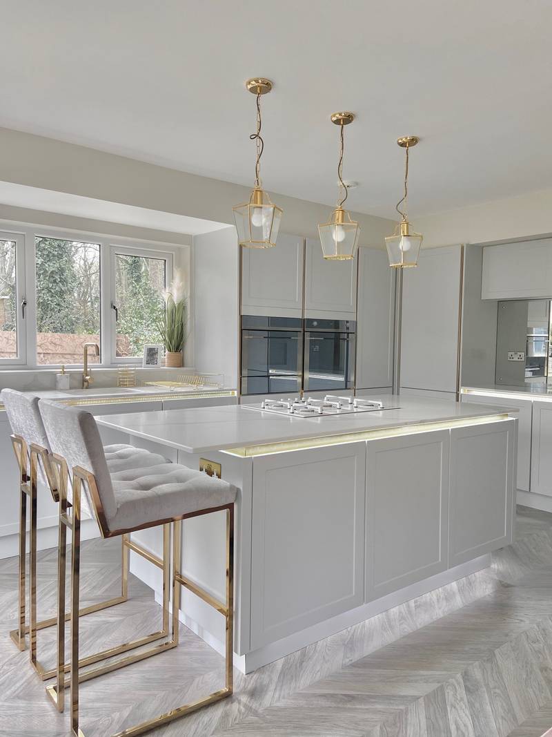 The Waugh family's stunning feminine 1920s Art Deco style kitchen, the Integra Dunham Dove Grey from Magnet, with a kitchen island paired with matching barstools.