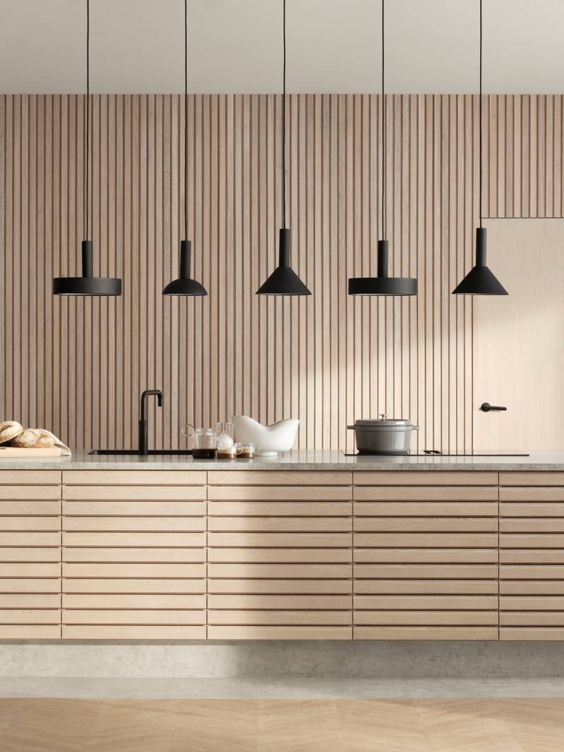 Egetræskøkkenø Ikon fra INVITA med håndsorterede lameller i massiv eg, mat sort armatur og sorte lamper.