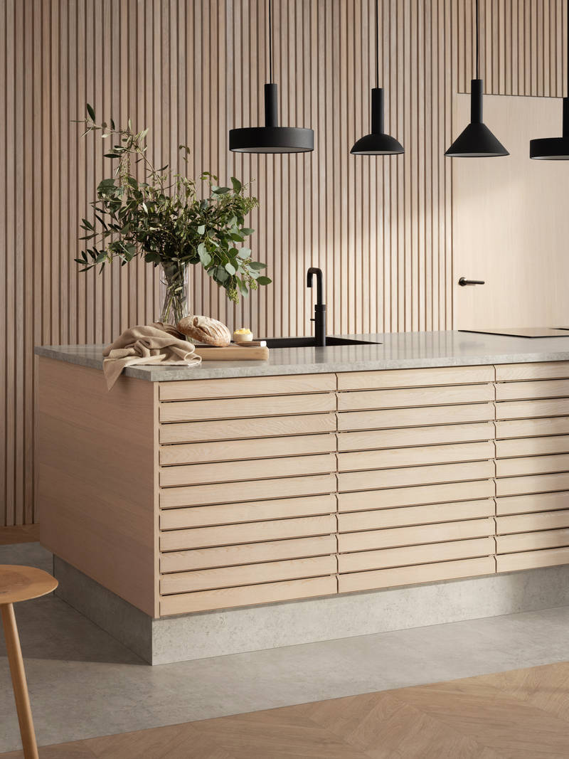 Nærbillede af egetræskøkkenø Ikon fra INVITA med håndsorterede lameller i massiv eg, mat sort armatur og sorte lamper